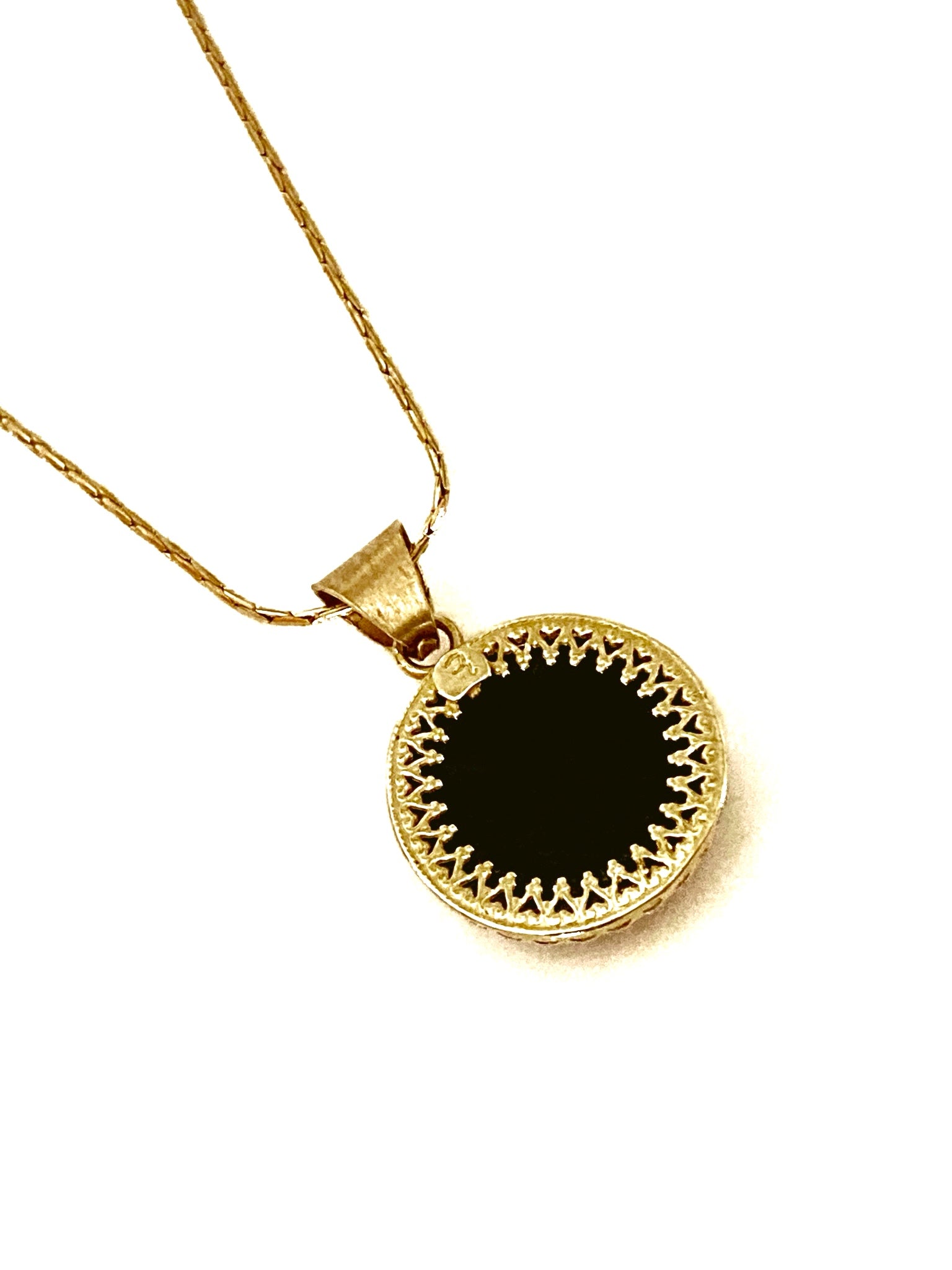 Back view of small, fused glass pendant set in brass.