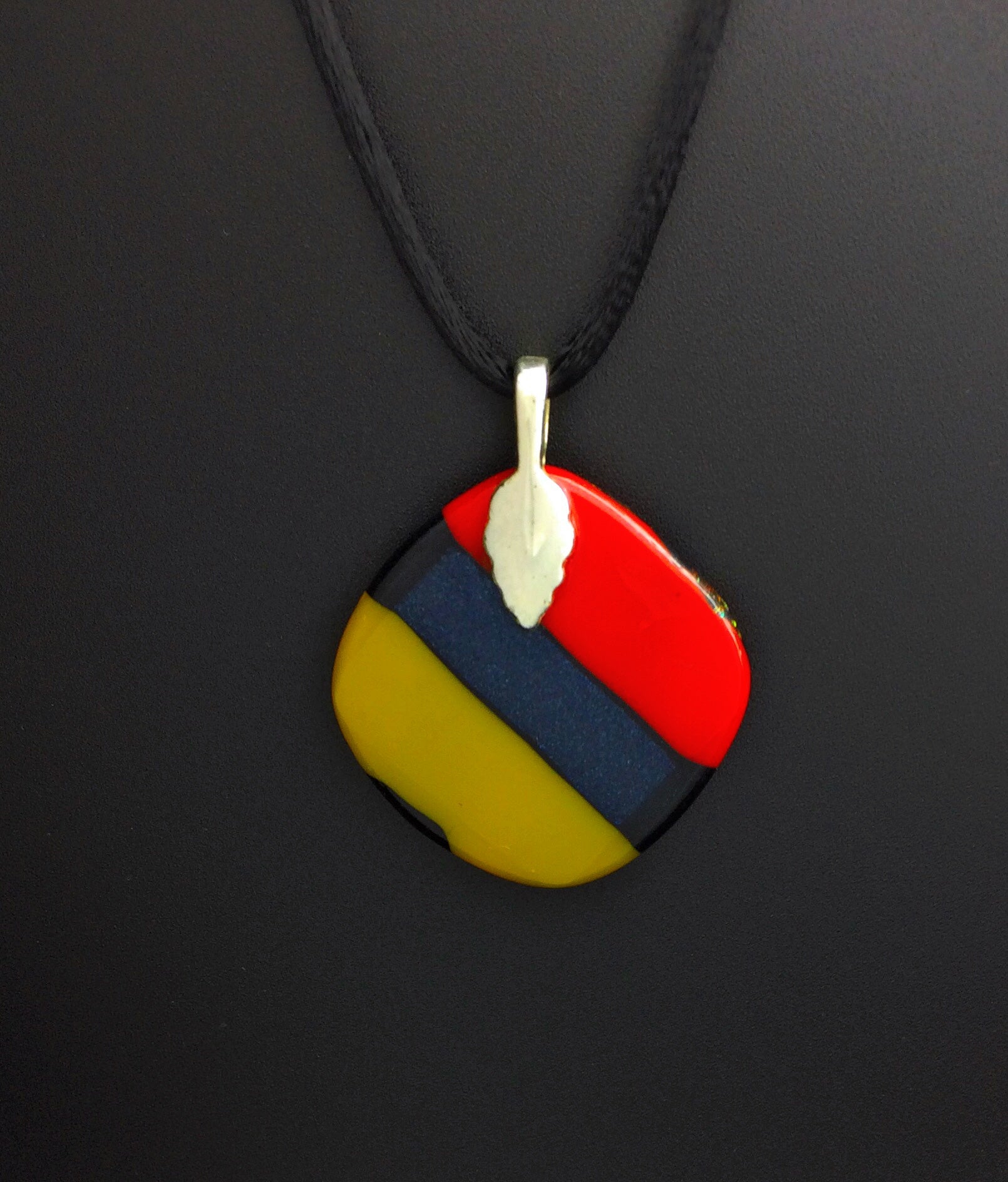 Backside of multicolored fused glass pendant.