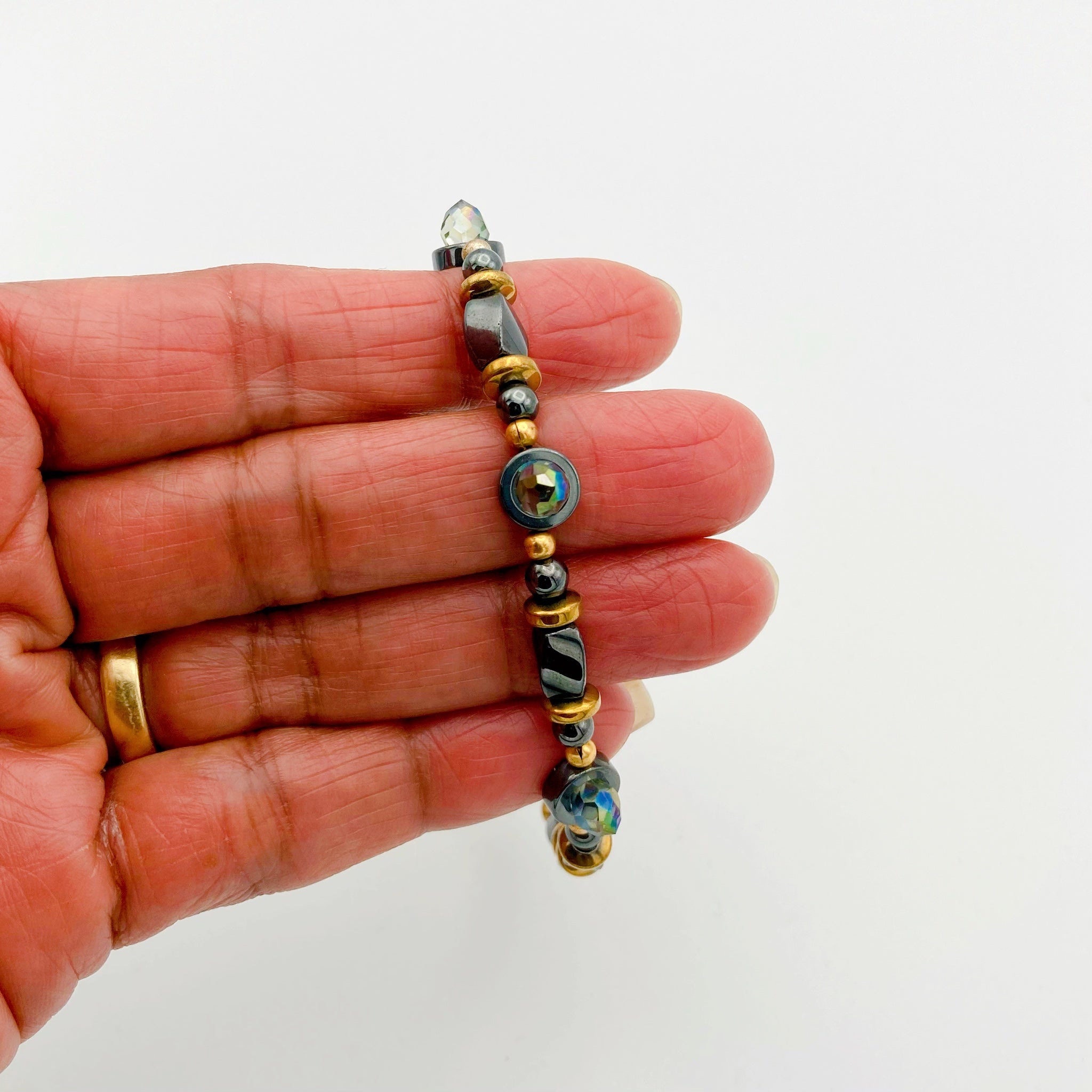 Hand holding hematite and crystal beaded bracelet, by 3D Glass Designs.