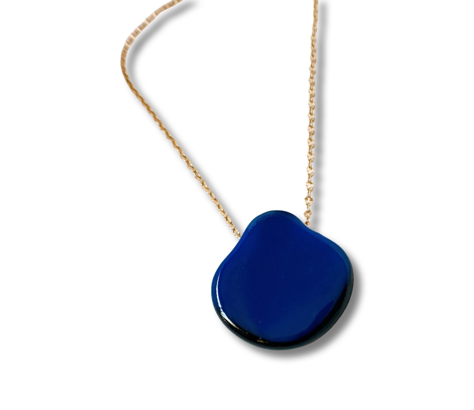 Vibrant blue fused glass on a gold chain against a white background, by 3D Glass Designs.
