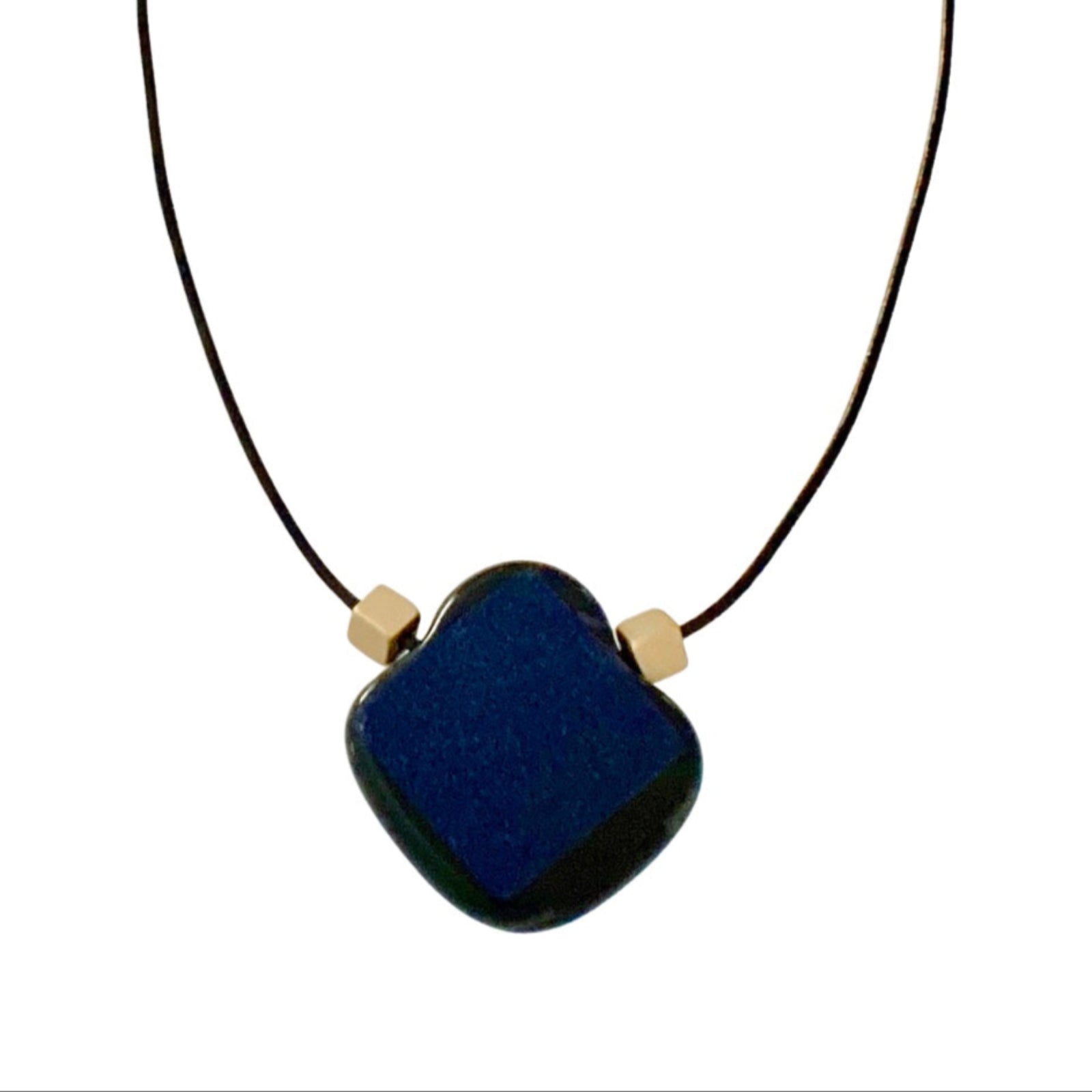 Blue glass pendant with gold cube beads on a leather cord against a white background, by 3D Glass Designs.