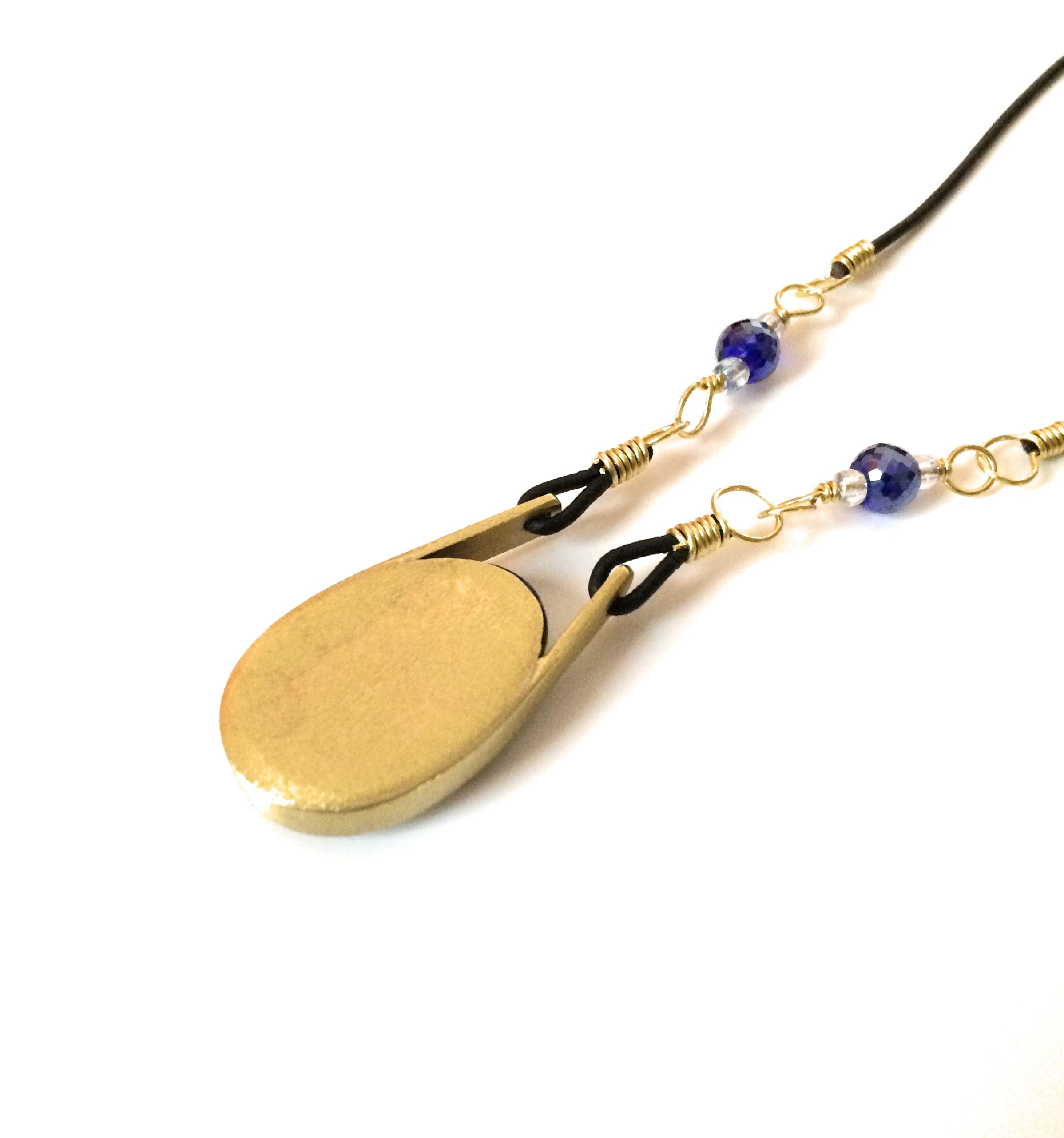 Back side of modern fused dichroic glass and brass pendant with a beaded leather cord, by 3D Glass Designs.