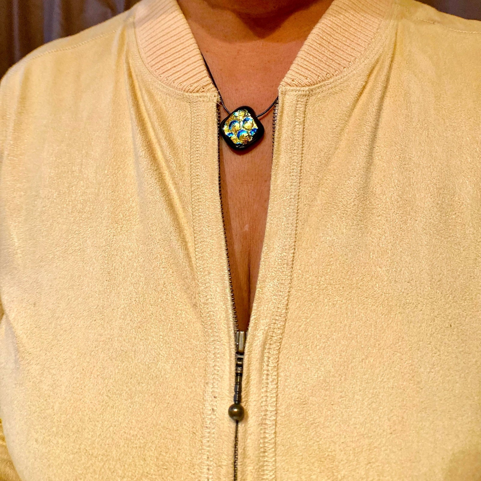 Model wearing diamond-shaped dichroic glass pendant in a yellow suede top, by 3D Glass Designs.