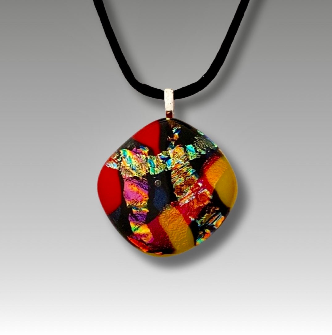 Colorful dichroic fused glass pendant in red, blue, yellow, purple, green and gold colors with a black satin cord. By 3D Glass Designs.