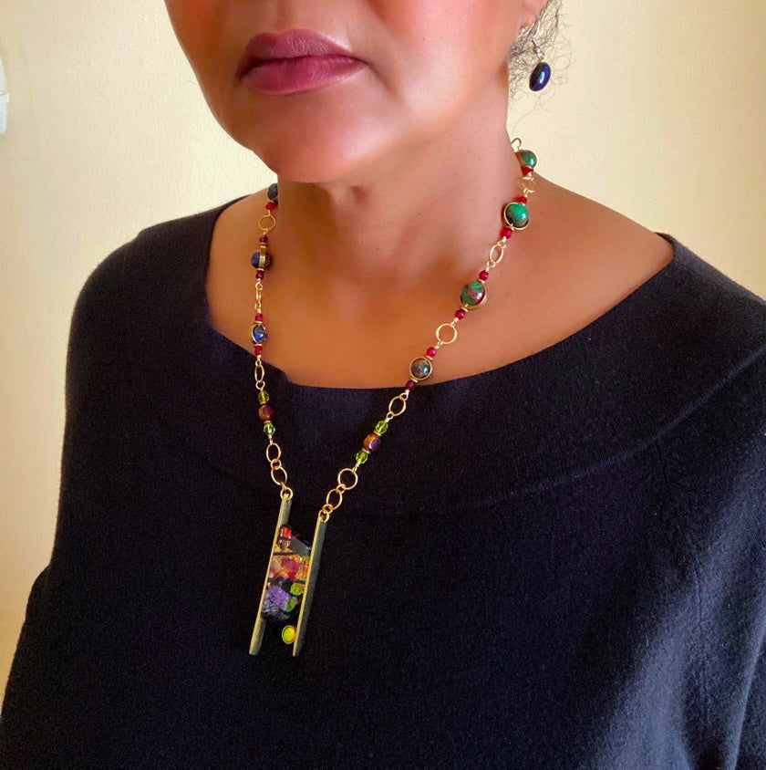 Model wearing brass pendant with colorful dichroic glass and beaded brass chain, by 3D Glass Designs.