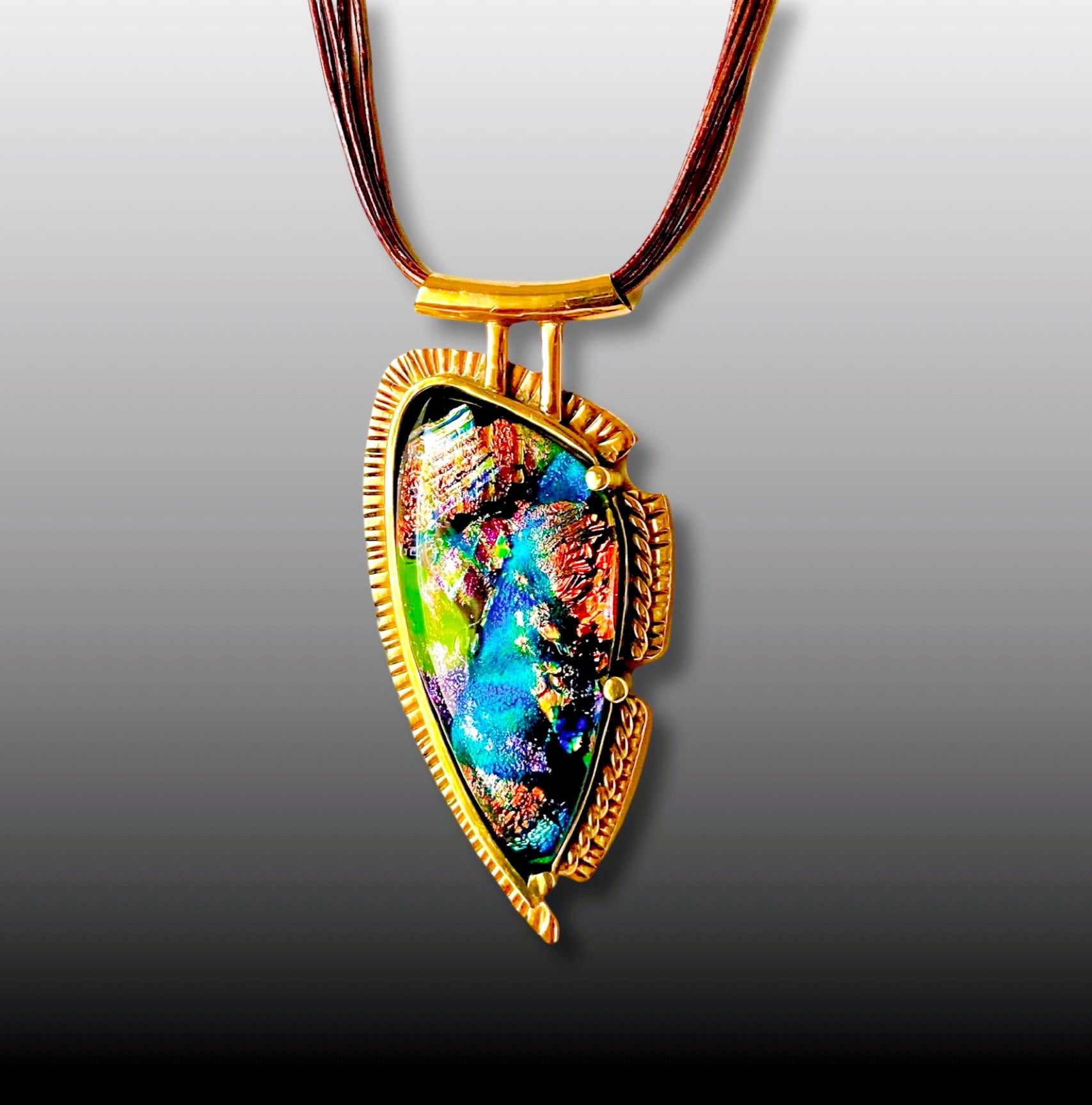 Handcrafted multicolor dichroic glass and brass pendant on a multistrand leather cord, by 3D Glass Designs.