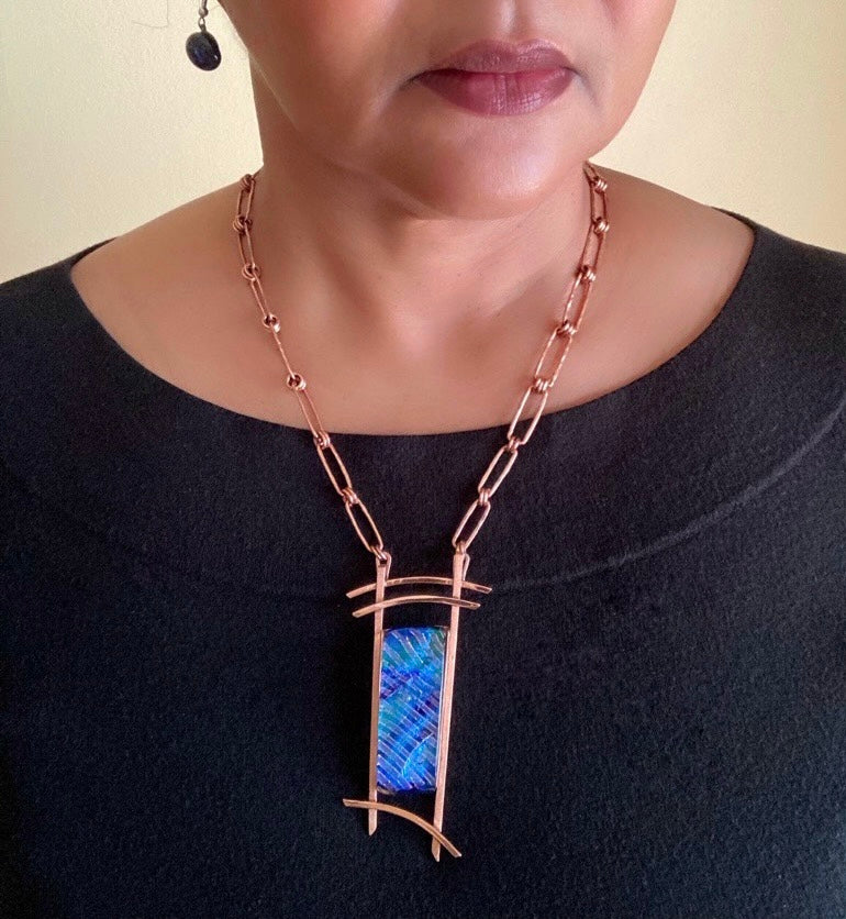 Model wearing contemporary dichroic glass and copper necklace by 3D Glass Designs.