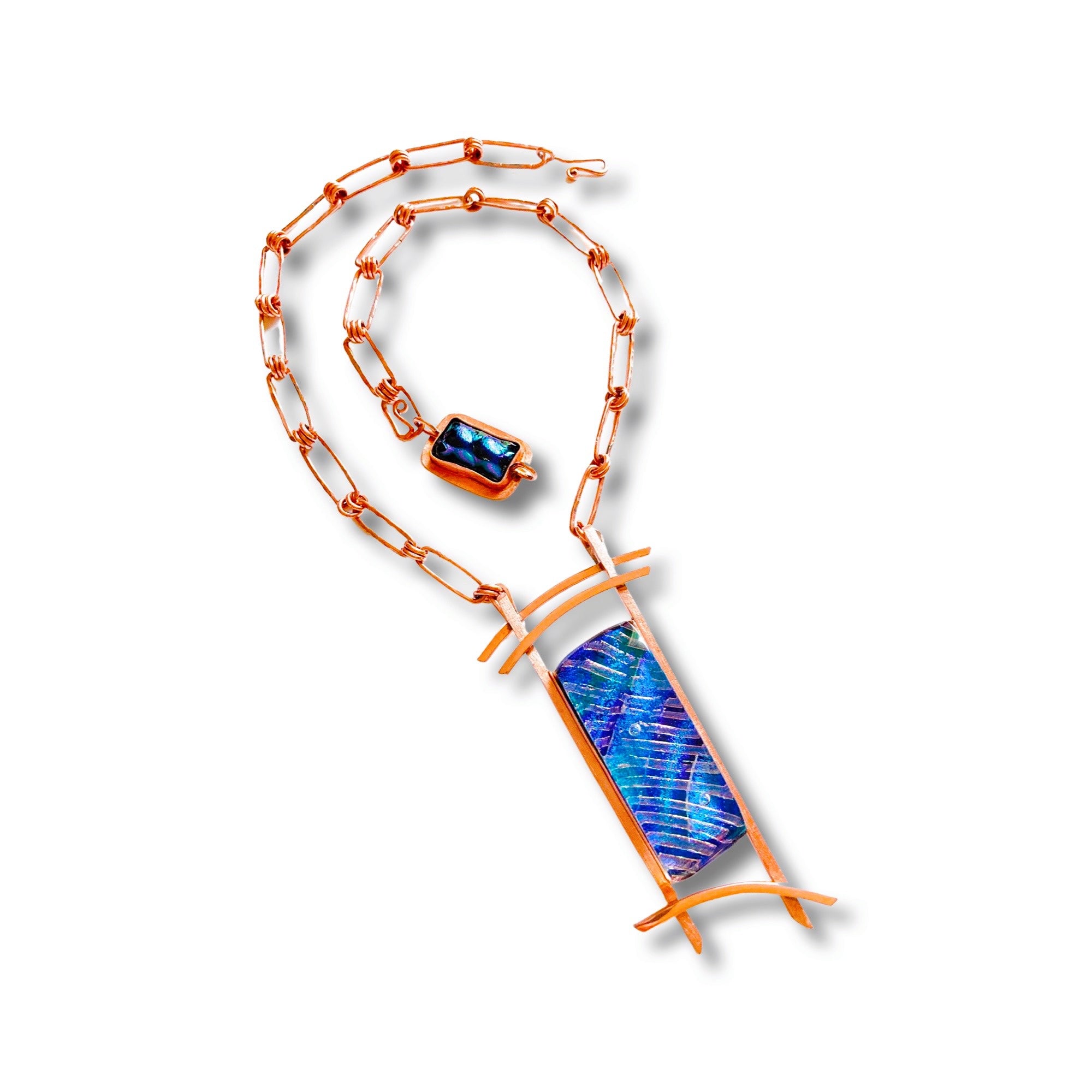 Blue dichroic glass set in a handcrafted copper pendant with an Asian design. Handmade copper paperclip link chain completes the design, by 3D Glass Designs
