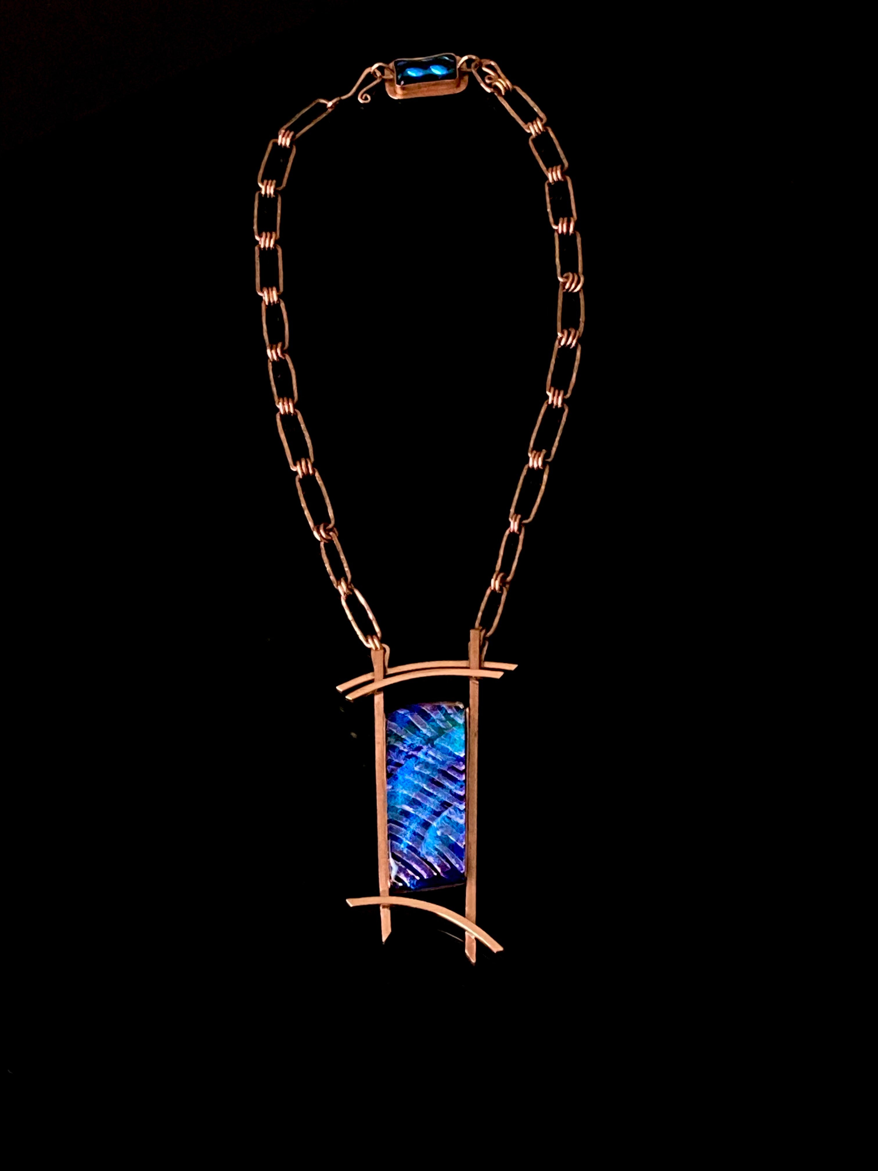 Blue dichroic glass set in a handcrafted copper pendant with an Asian design. Handmade copper paperclip link chain completes the design, by 3D Glass Designs