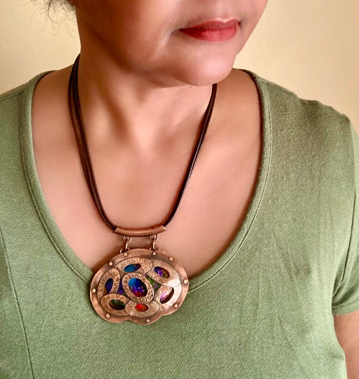 Model wearing copper and dichroic glass oval pendant necklace by 3D Glass Designs.