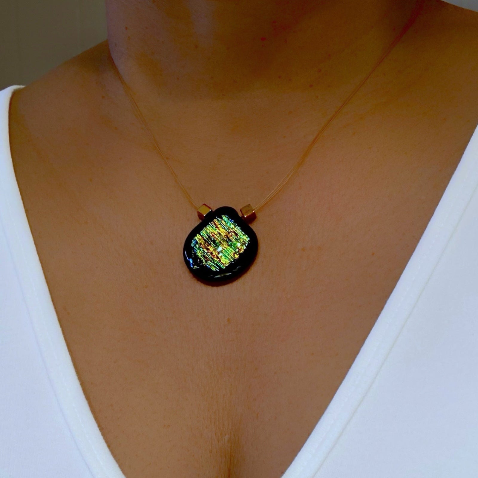 Model wearing fused glass pendant on a delicate necklace, by 3D Glass Designs.