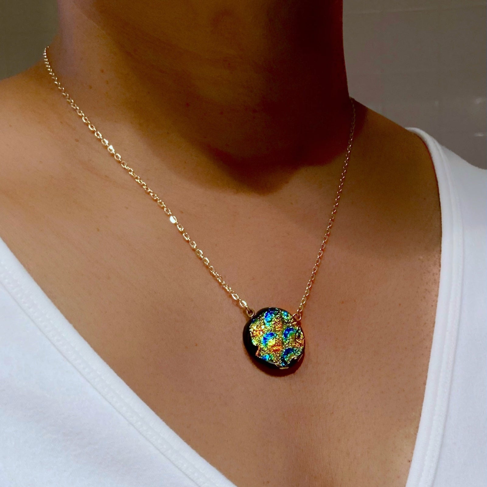 Model wearing dainty dichroic glass pendant necklace, by 3D Glass Designs.