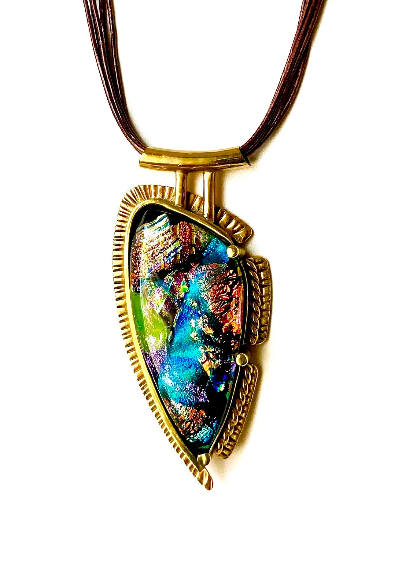Handcrafted brass pendant featuring multicolored dichroic glass in a shield-shape hung on a multistrand leather necklace, by 3D Glass Designs.