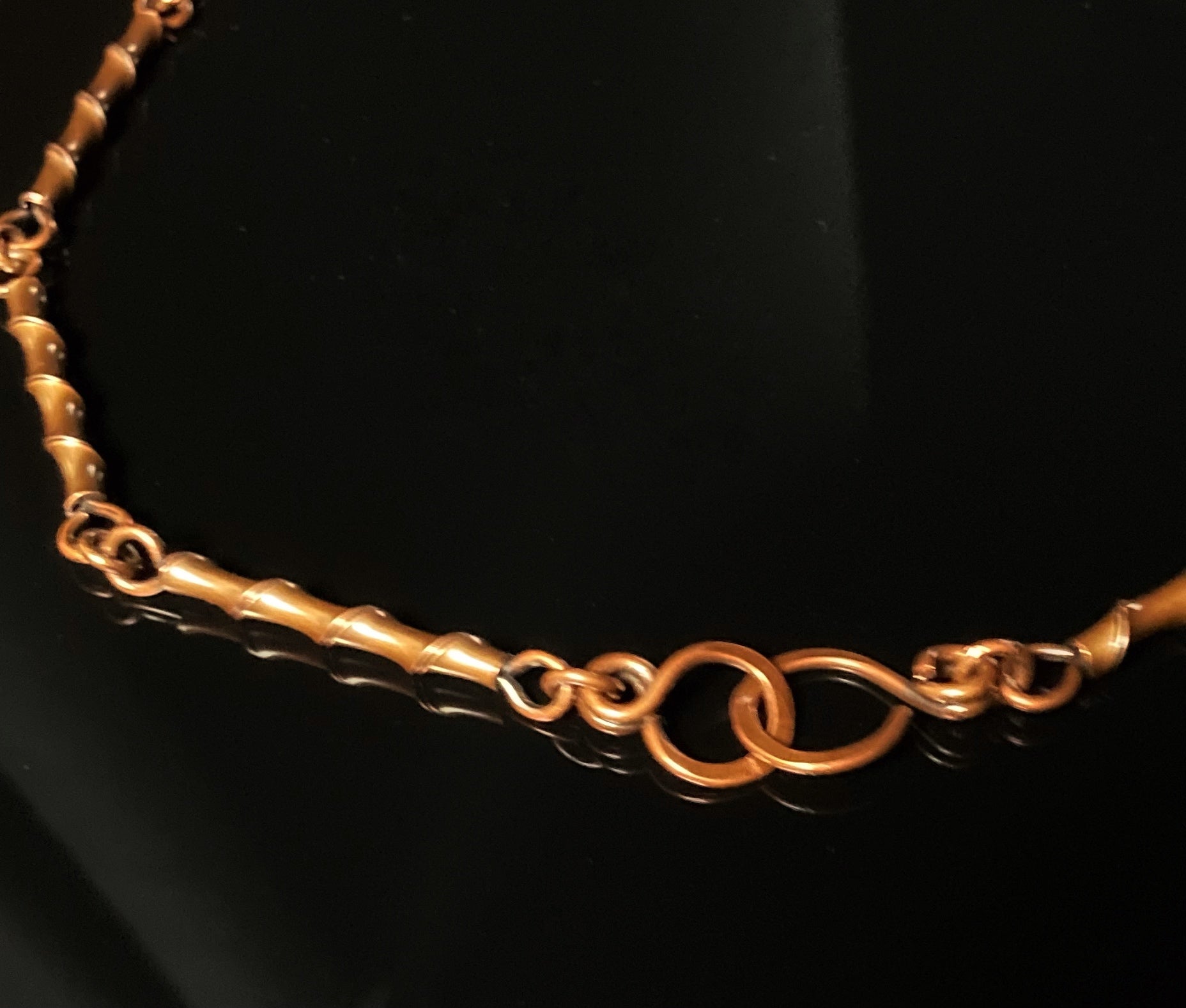 Details of handcrafted copper necklace links that resembles bamboo and handmade clasp by 3D Glass Designs.
