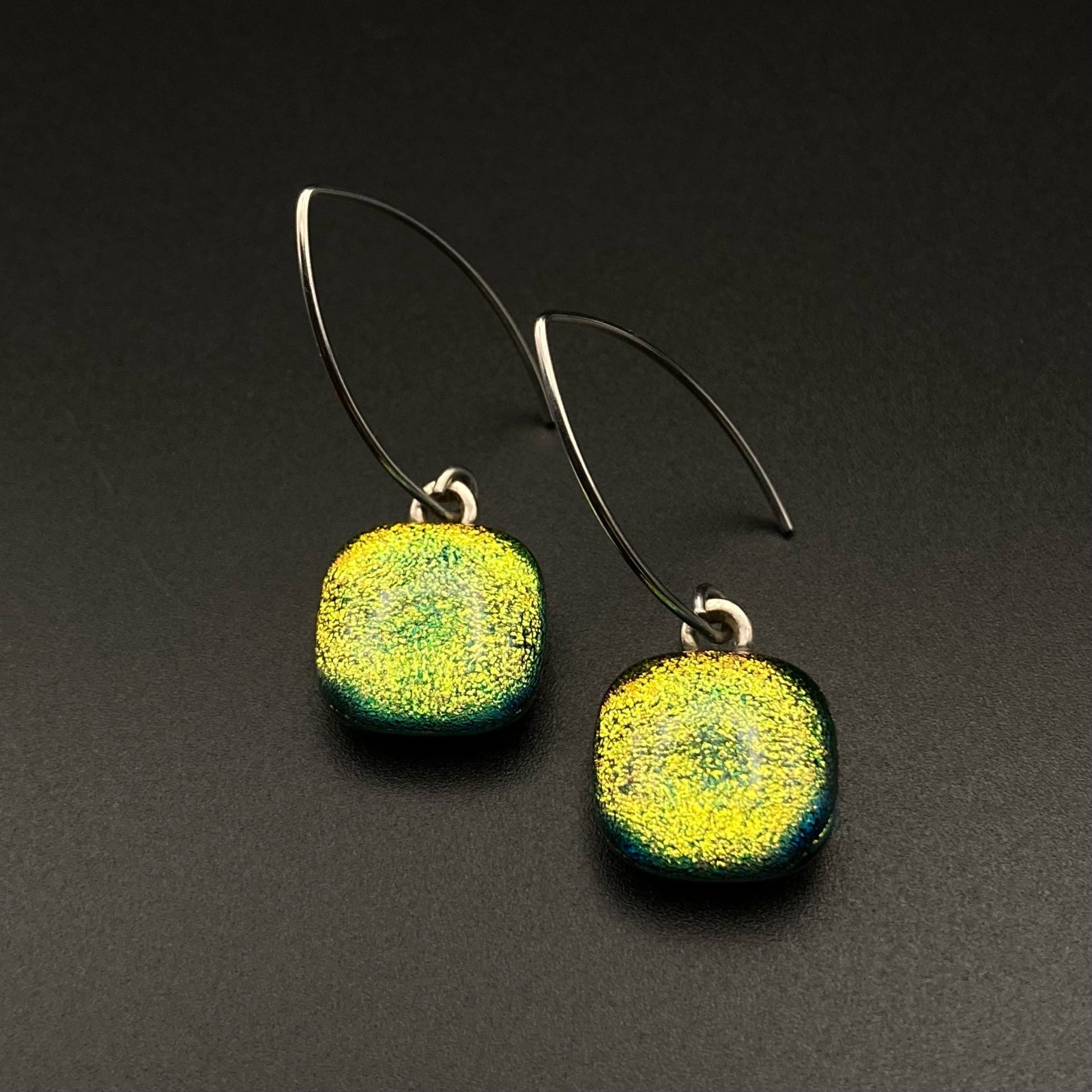 A pair of yellow glass earrings with silver ear wires against a grey background, by 3D Glass Designs.