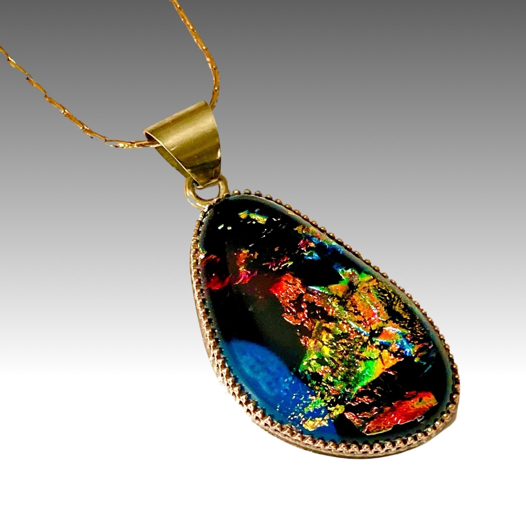 Handmade fused glass pendant in teal, green, orange, gold, black and red set in brass. By 3D Glass Designs.