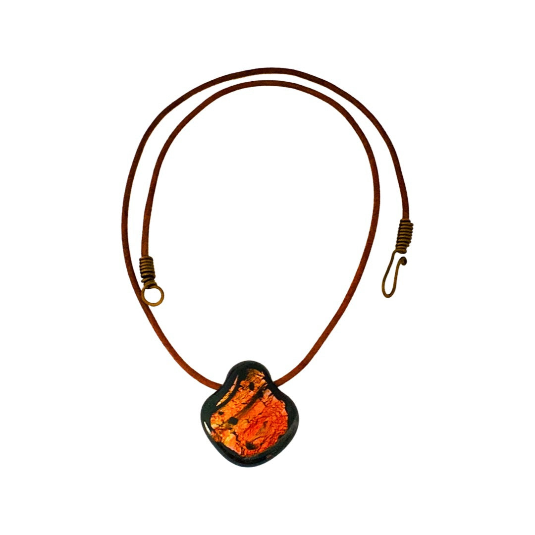 Reddish color fused glass pendant on a brown leather cord against a white background, by 3D Glass Designs.