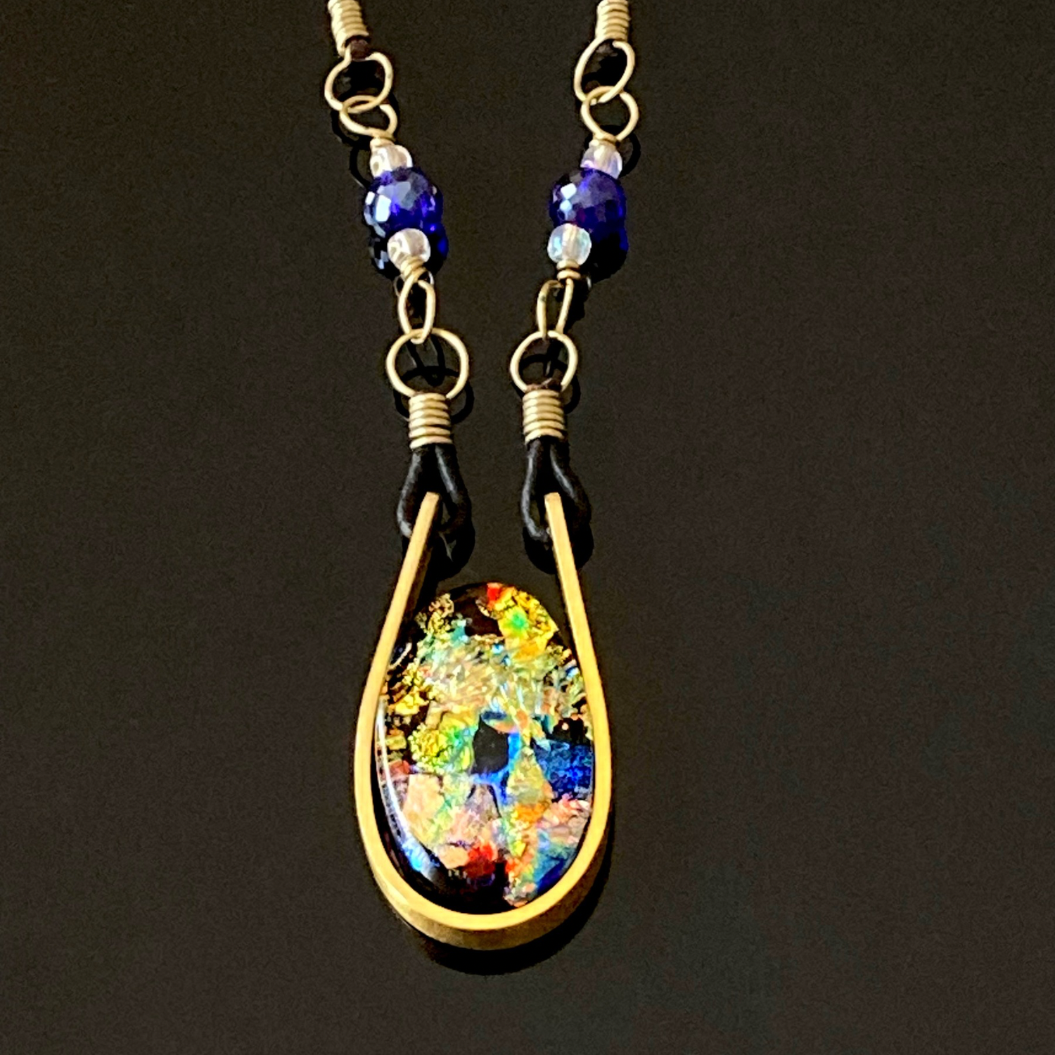 Modern fused dichroic glass and brass pendant with a beaded leather cord, by 3D Glass Designs.