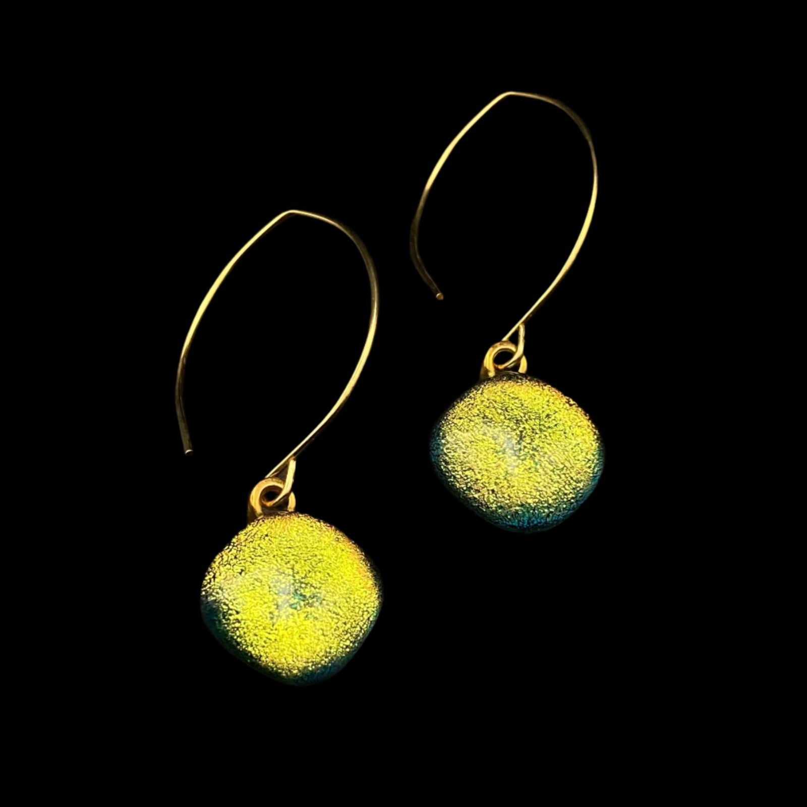 Yellow dichroic glass earrings with gold ear wires against a black background, by 3D Glass Designs.