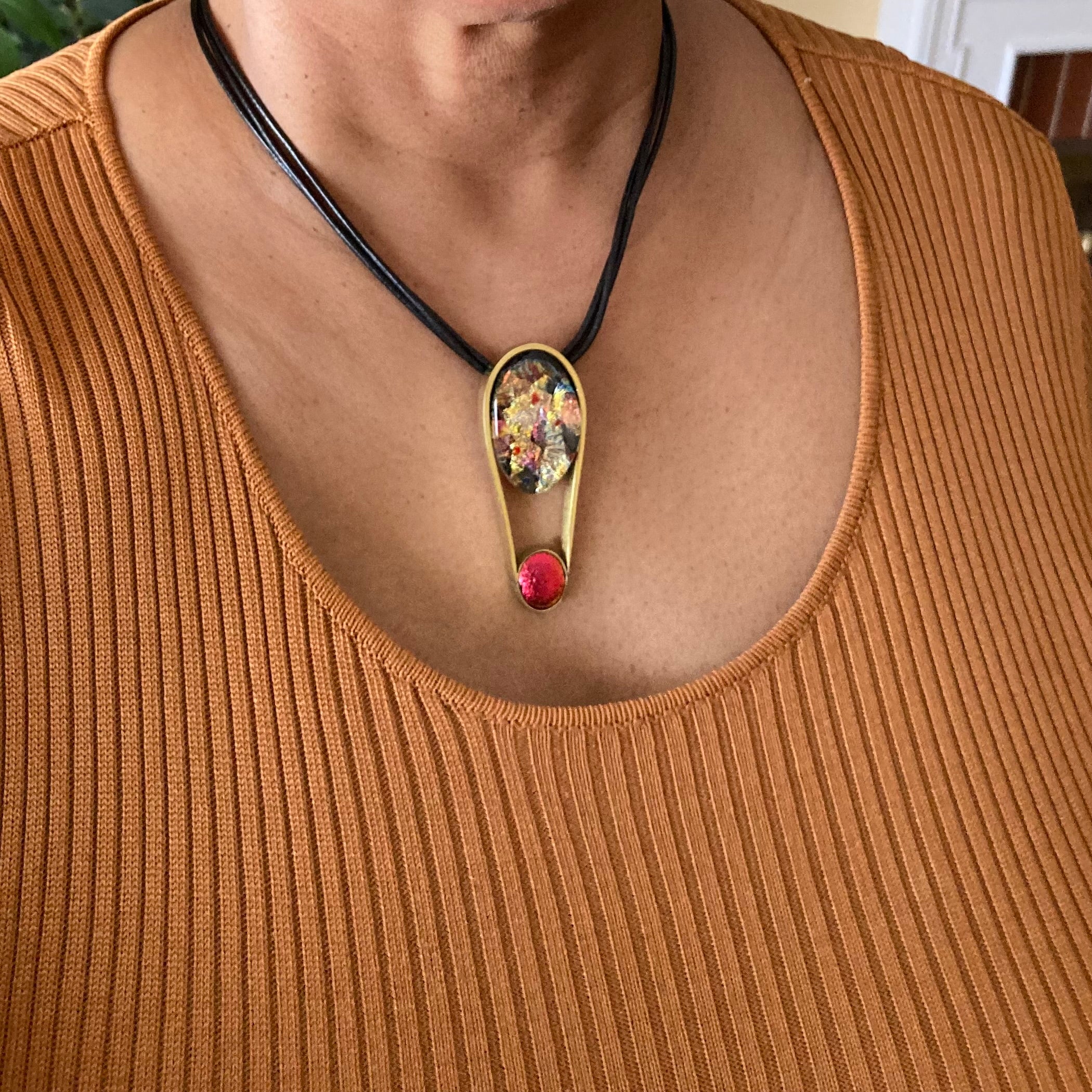 Model wearing contemporary fused glass pendant set in brass, by 3D Gass Designs.