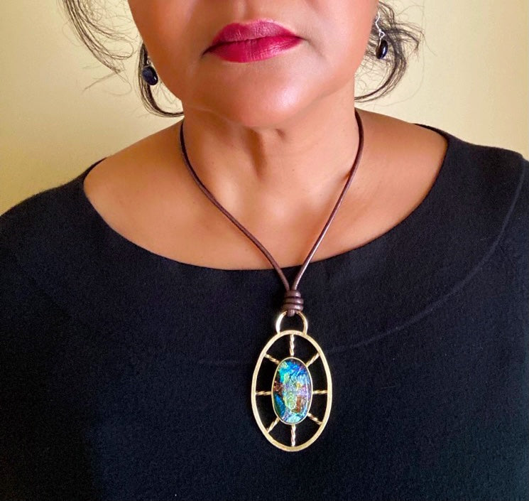 Model wearing nautical inspired dichroic glass and brass pendant, by 3D Glass Designs.