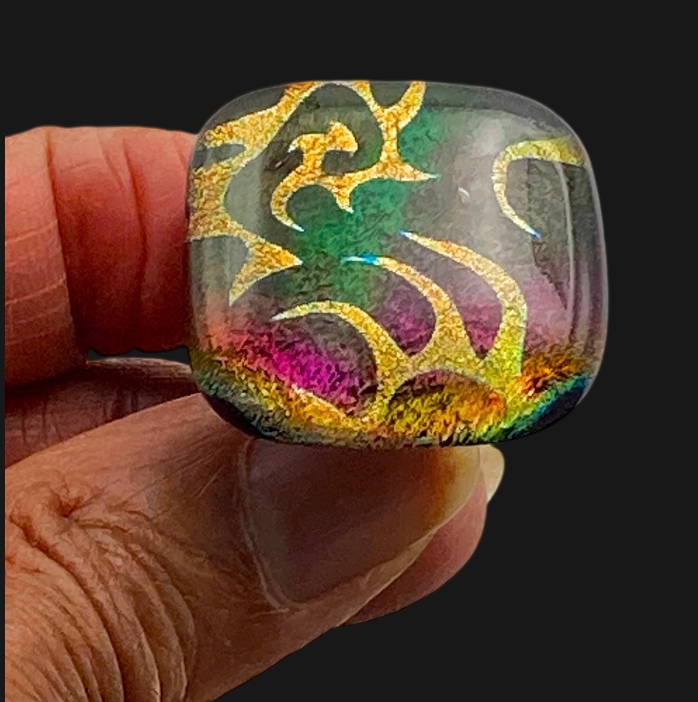 Hand holding handmade dichroic glass knob, by 3D Glass Design.
