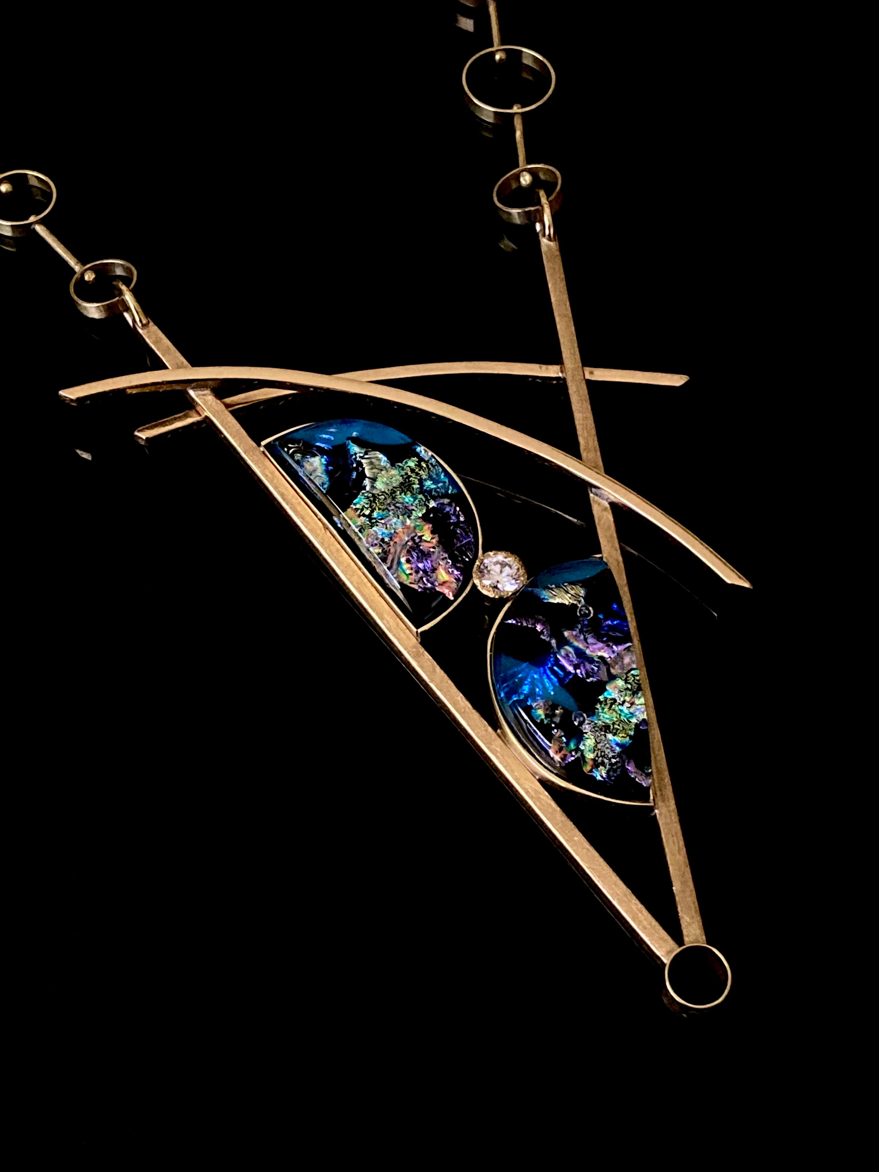 Geometric inspired brass pendant with teal fused glass in semi-circles and CZ, framed in a V with two slightly curved arch's above. Necklace made of various sized circles linked together, by 3D Glass Designs.