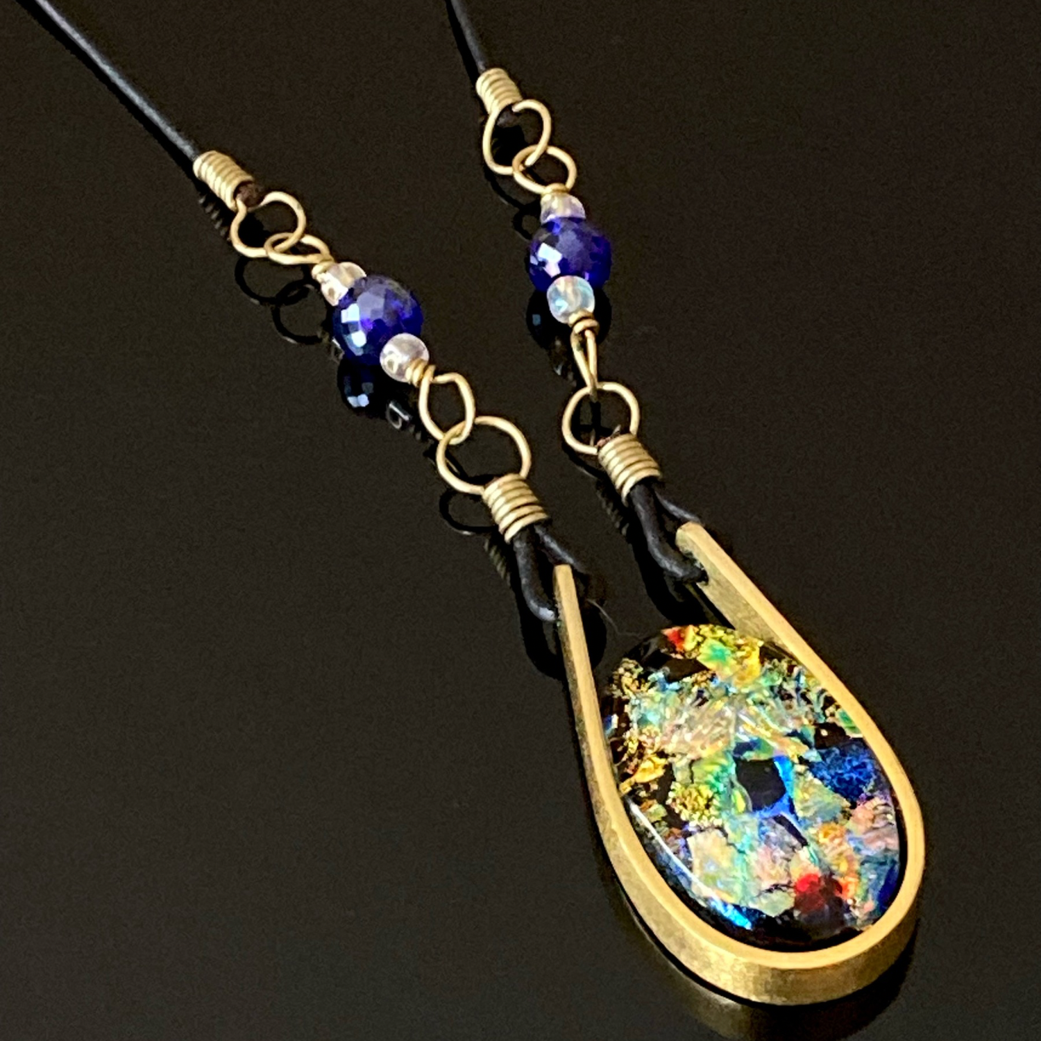 Modern fused dichroic glass and brass pendant with a beaded leather cord, by 3D Glass Designs.