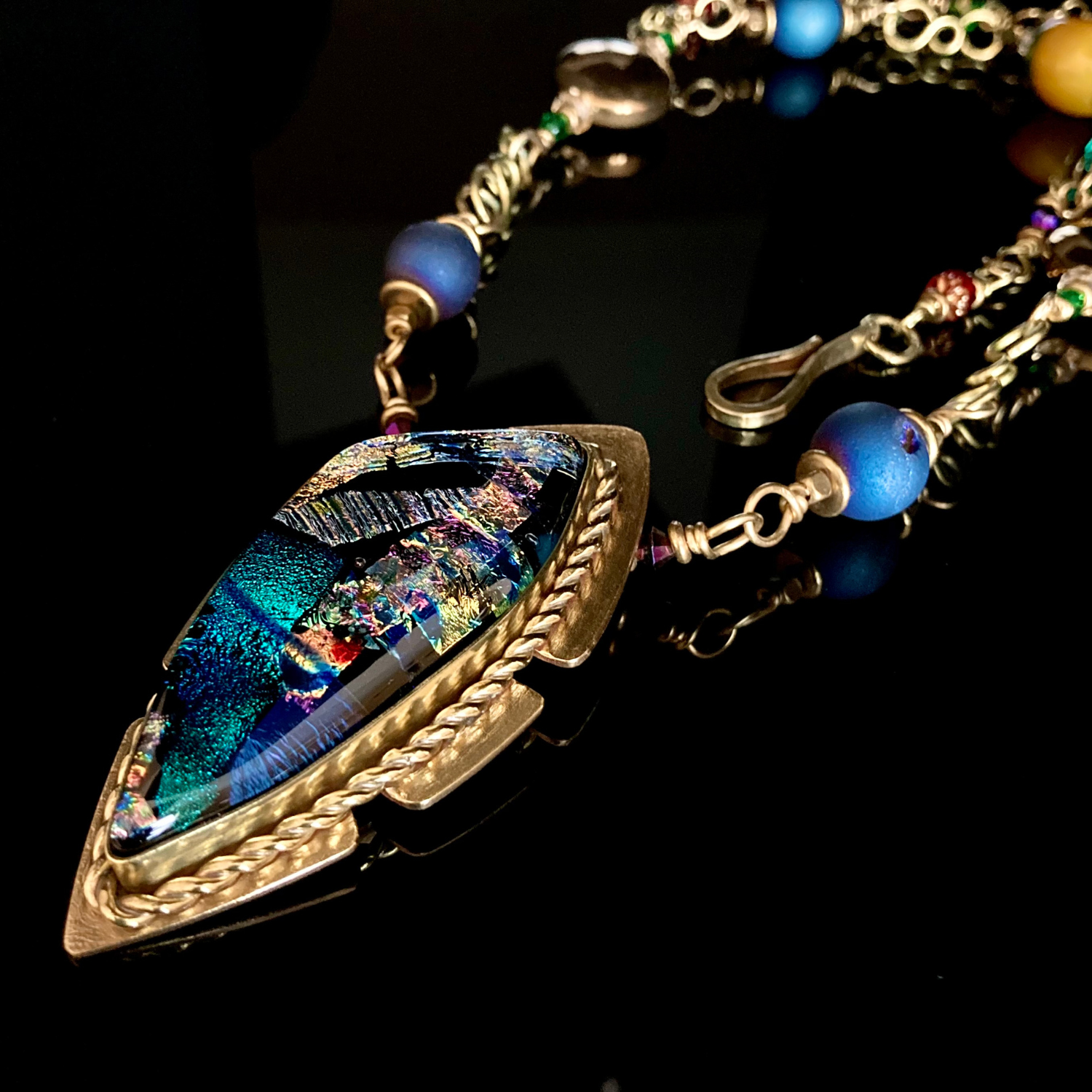 Multicolor handcrafted dichroic glass pendant set in brass, with a handmade beaded chain. By 3D Glass Designs.