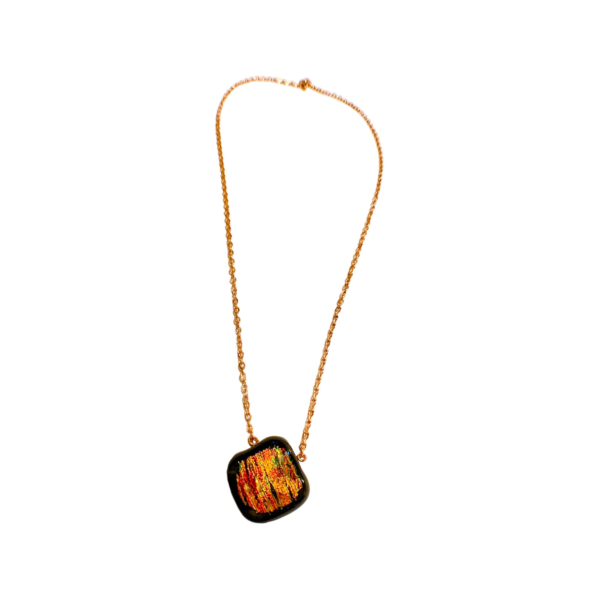 Orange dichroic glass pendant on a gold chain against a white background, by 3D Glass Designs.