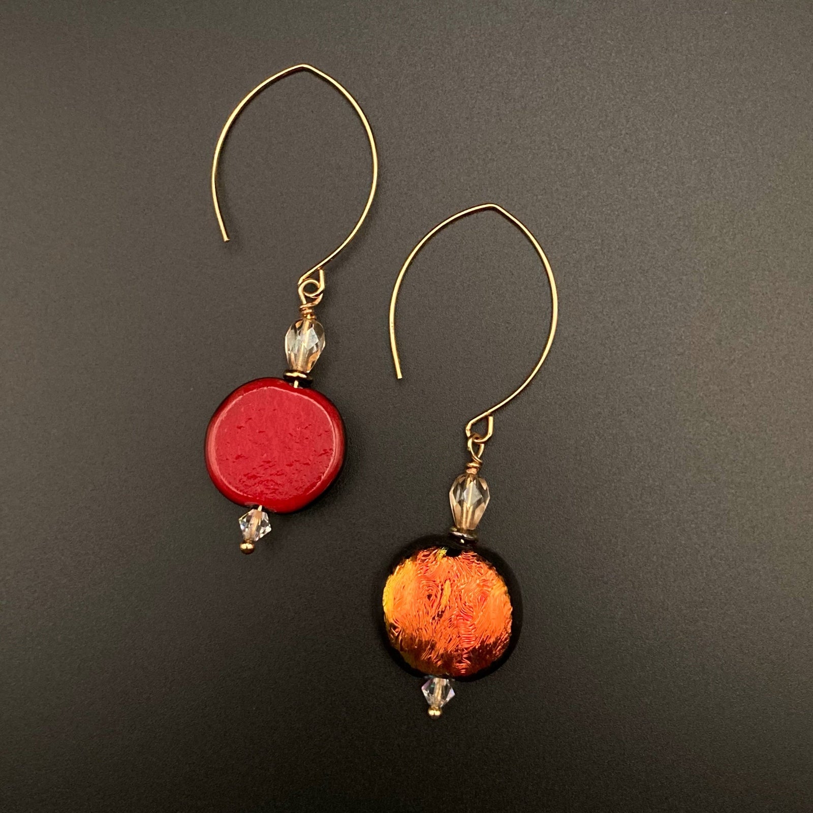 A pair of reversible glass earrings, one side red and the other side orange, by 3D Glass Designs.