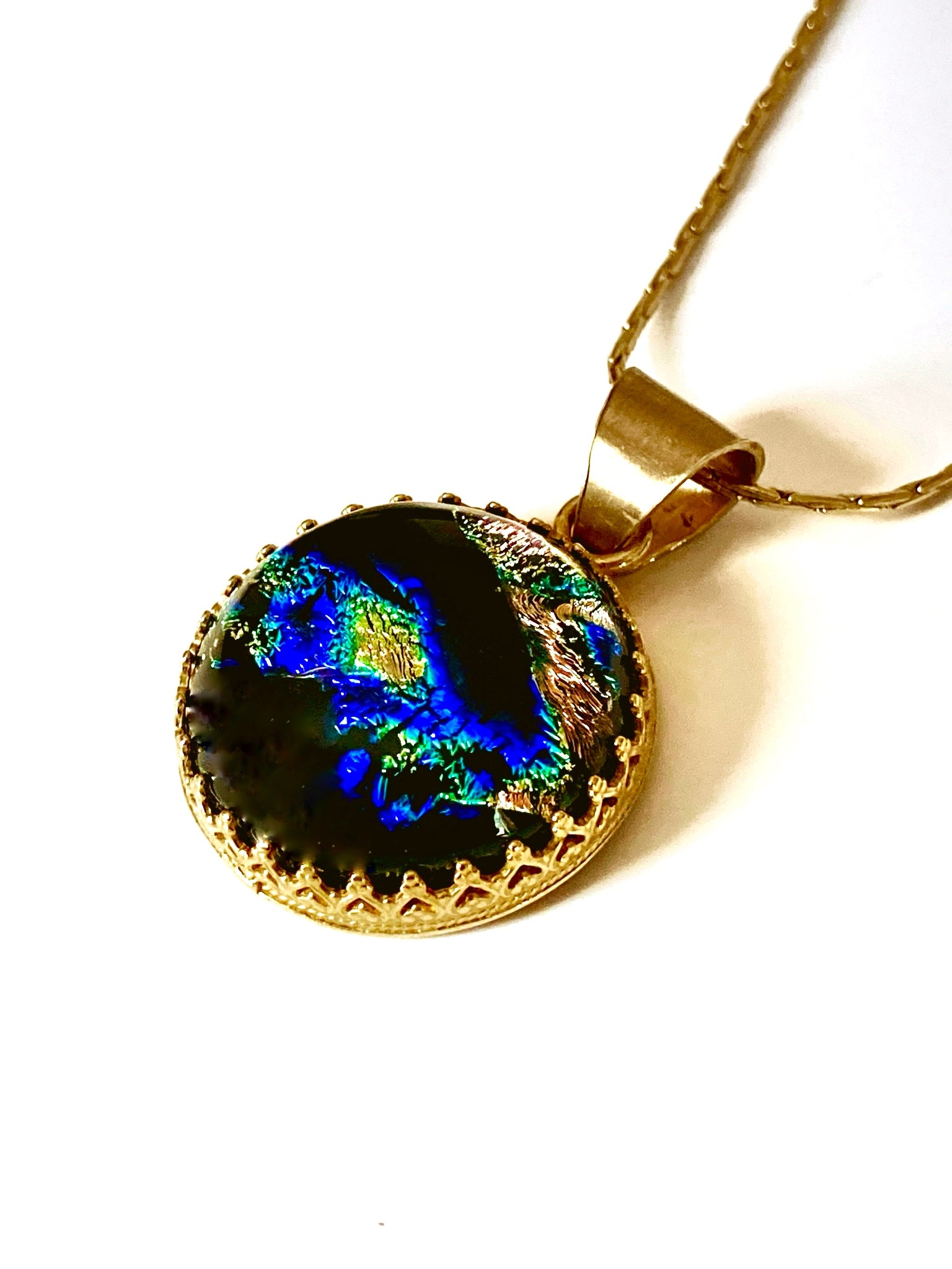 Small round fused glass pendant set in brass with a gold-plated chain.