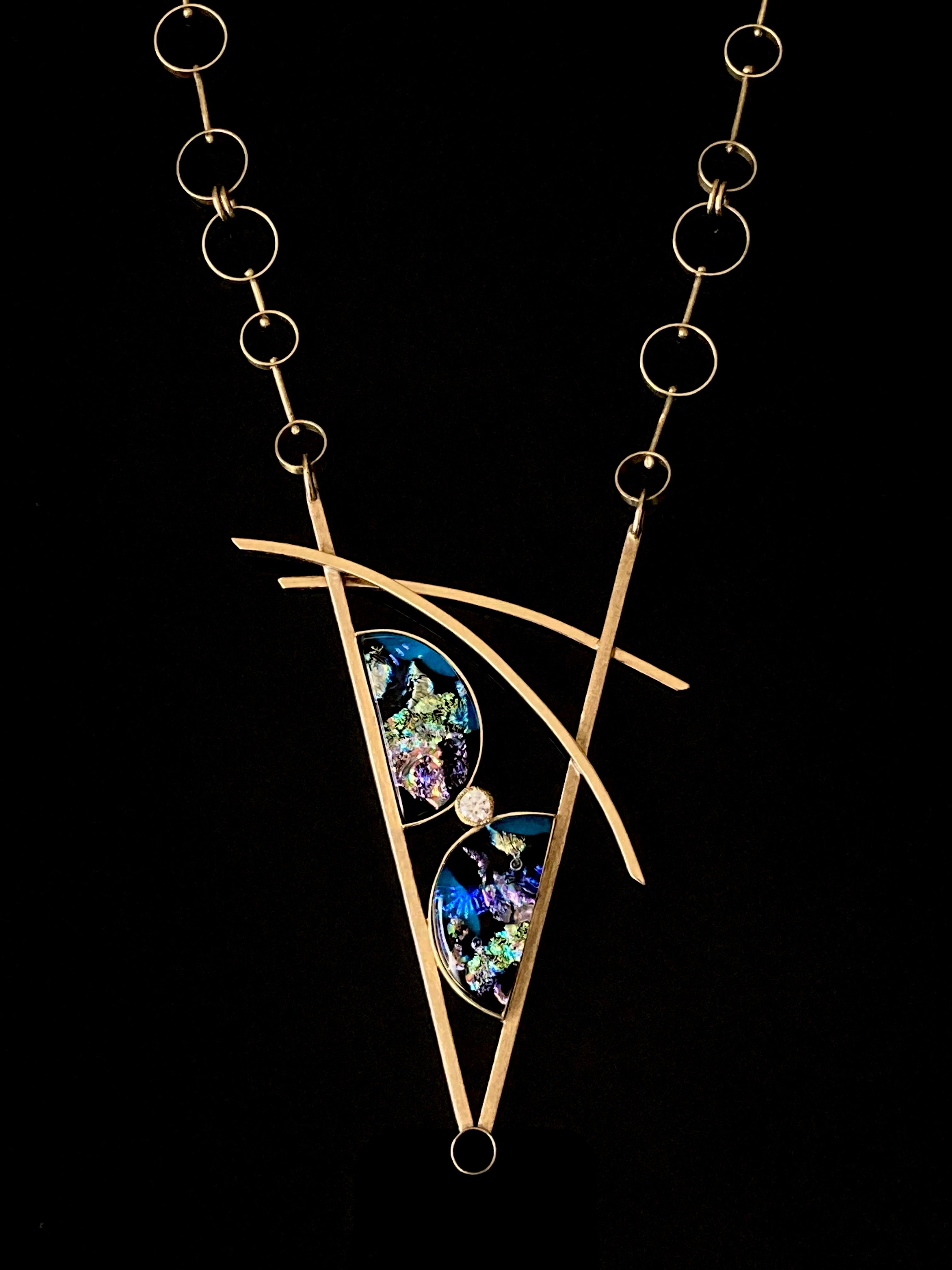 Geometric inspired brass pendant with teal fused glass in semi-circles and CZ, framed in a V with two slightly curved arch's above. Necklace made of various sized circles linked together, by 3D Glass Designs.