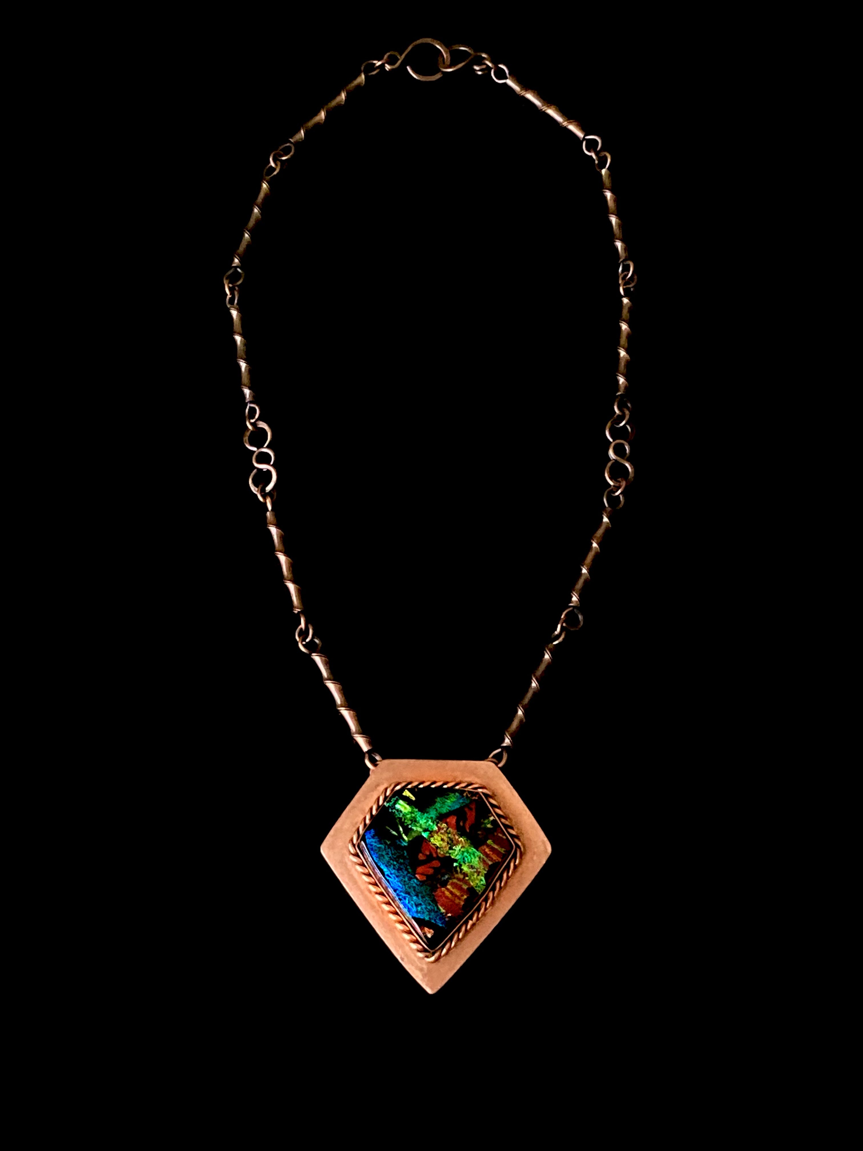 Unique copper and fused glass pendant necklace by 3D Glass Designs. Dichroic glass in blue, green and rust hues set in a handcrafted diamond-shaped shield copper pendant with an elegant rope detail surrounding the bezel. The handmade copper necklace consists of twisted copper links that resembles bamboo and a handmade clasp.