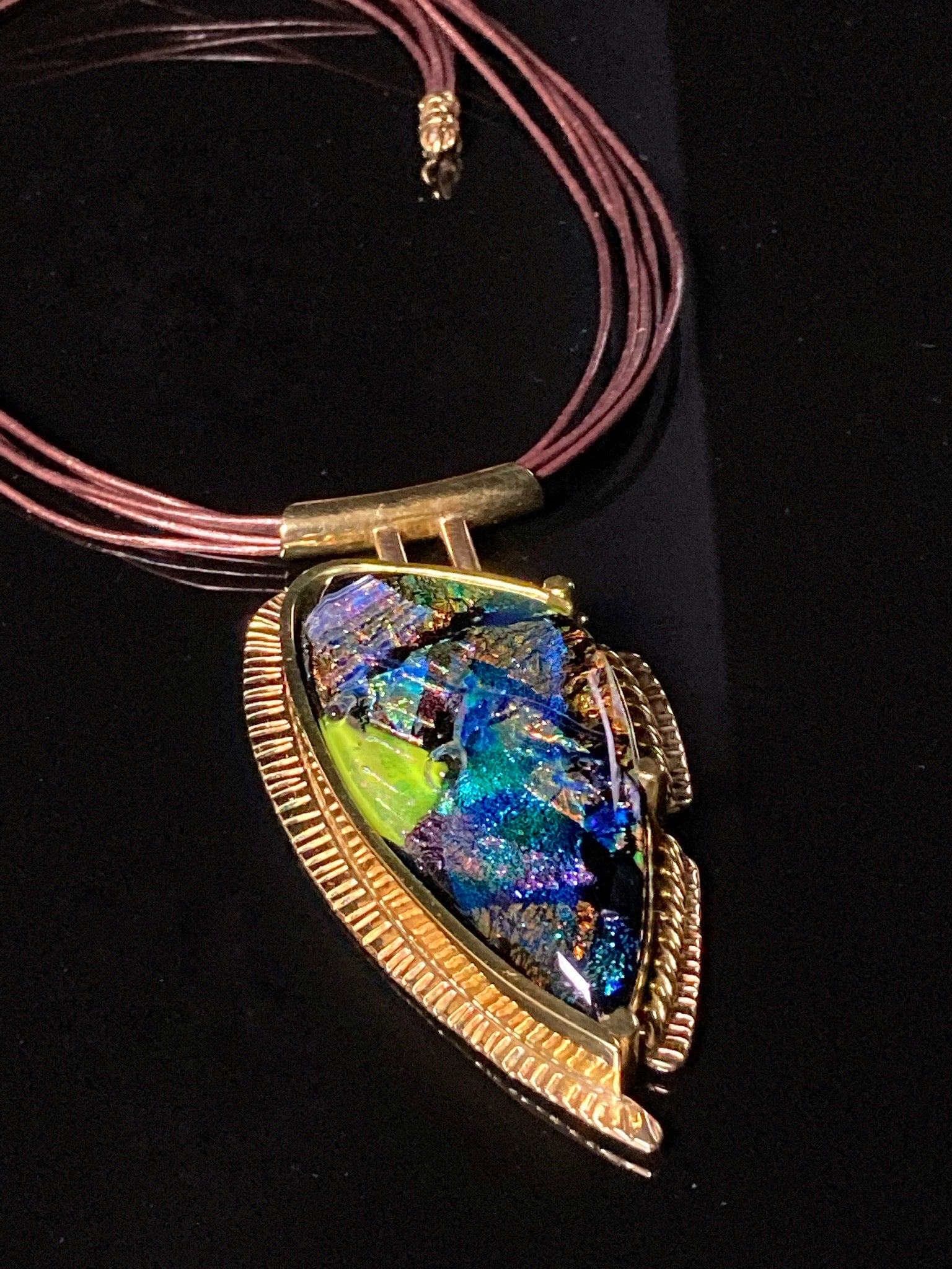 Multicolor fused glass set in a handmade brass pendant with a multistrand leather necklace, by 3D Glass Designs.