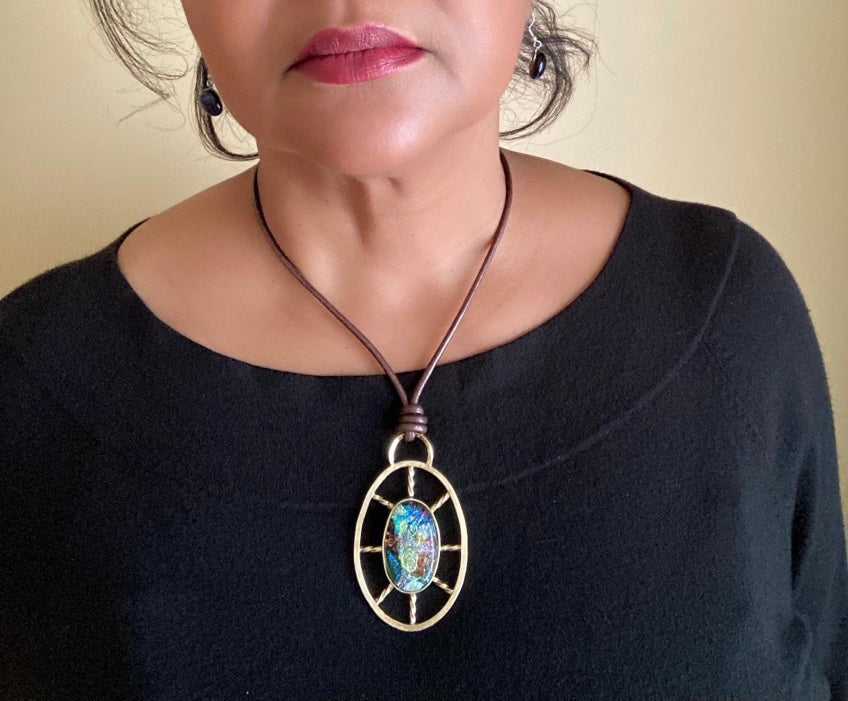 Model wearing Nautical inspired multicolor dichroic glass set in a brass oval wheel shaped design, by 3D Glass Designs.