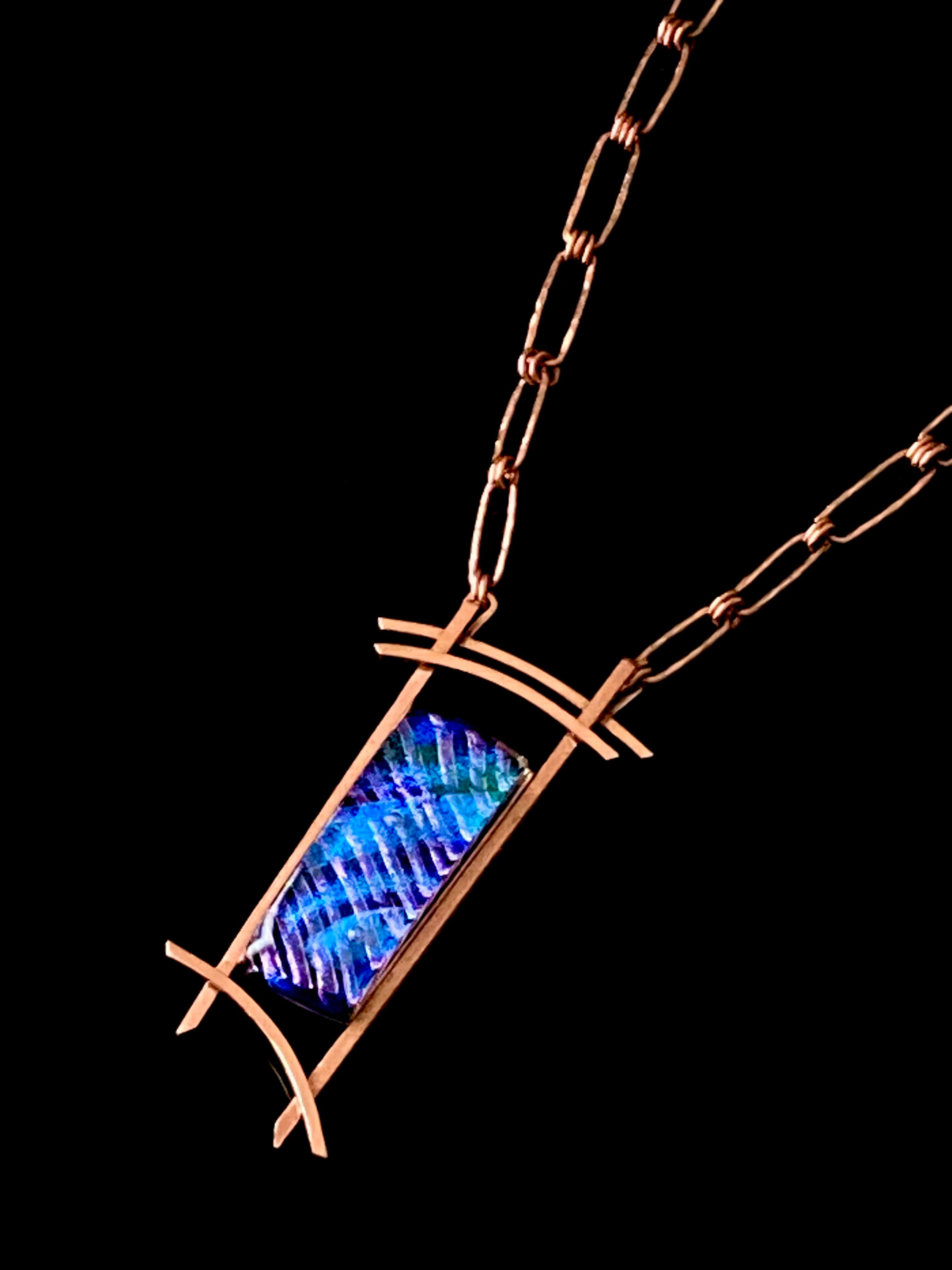 Blue dichroic glass set in a handcrafted copper pendant with an Asian design. Handmade copper paperclip link chain completes the design, by 3D Glass Designs