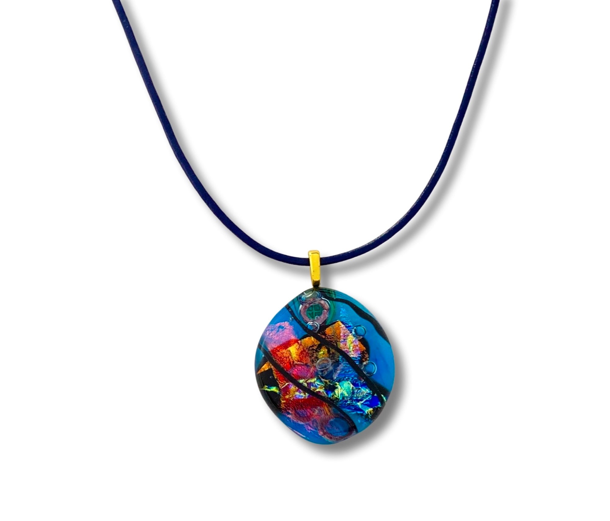 Fused glass pendant on a blue leather cord. Transparent blue glass with layers of red, rust, blue, green and purple dichroic glass and a copper squiggle design embedded in the glass. By 3D Glass Designs