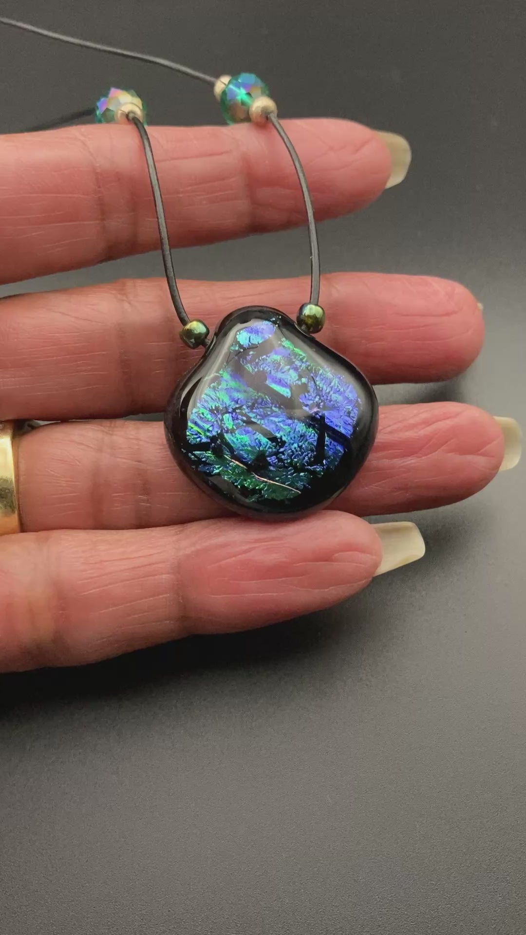 Hand holding fused glass pendant, by 3D Glass Designs.