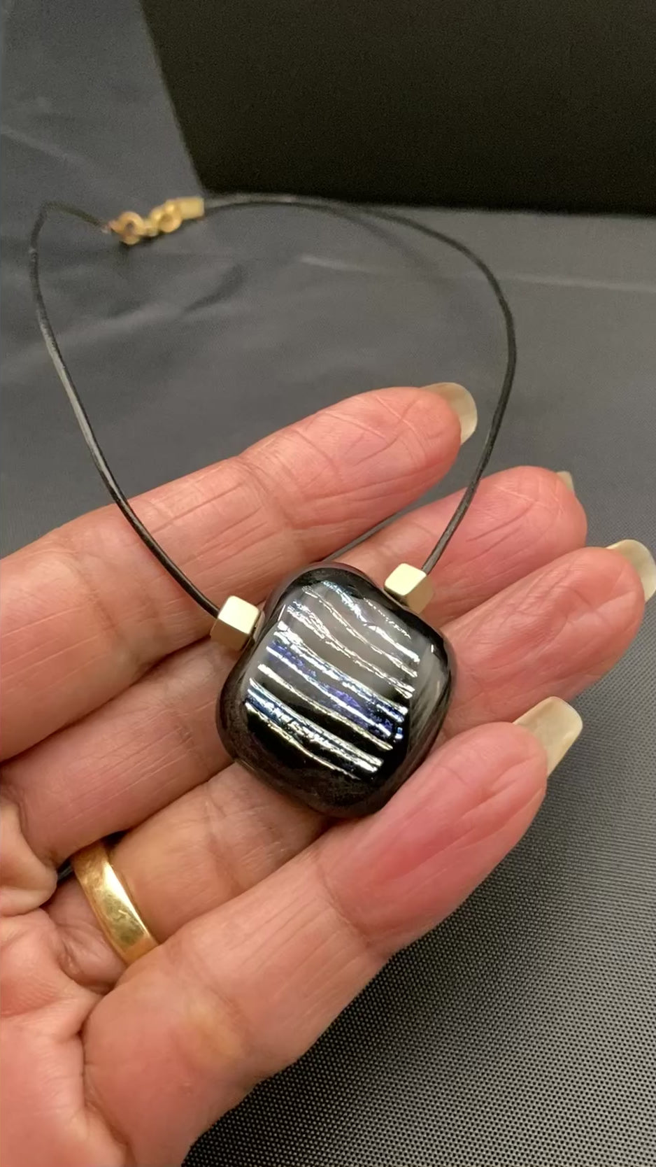 Hand holding small glass pendant, by 3D Glass Designs.