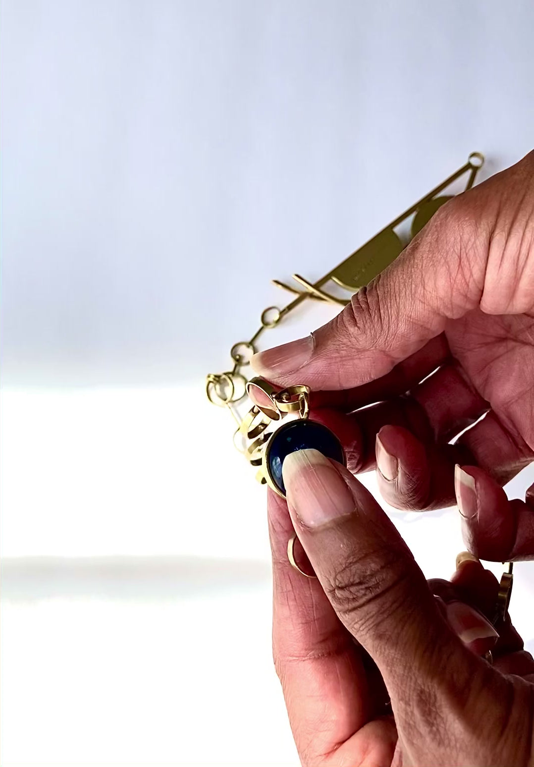 Video demonstrating how to open and close the clasp on brass and dichroic glass pendant, by 3D Glass Designs.