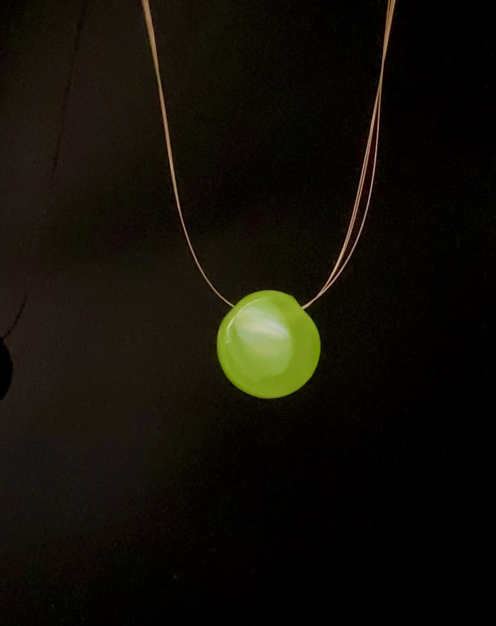 Small round glass pendant, green blue and gold on front with lime green on back. Illusion style pendant necklace on three thin gold beading wires, by 3D Glass Designs.