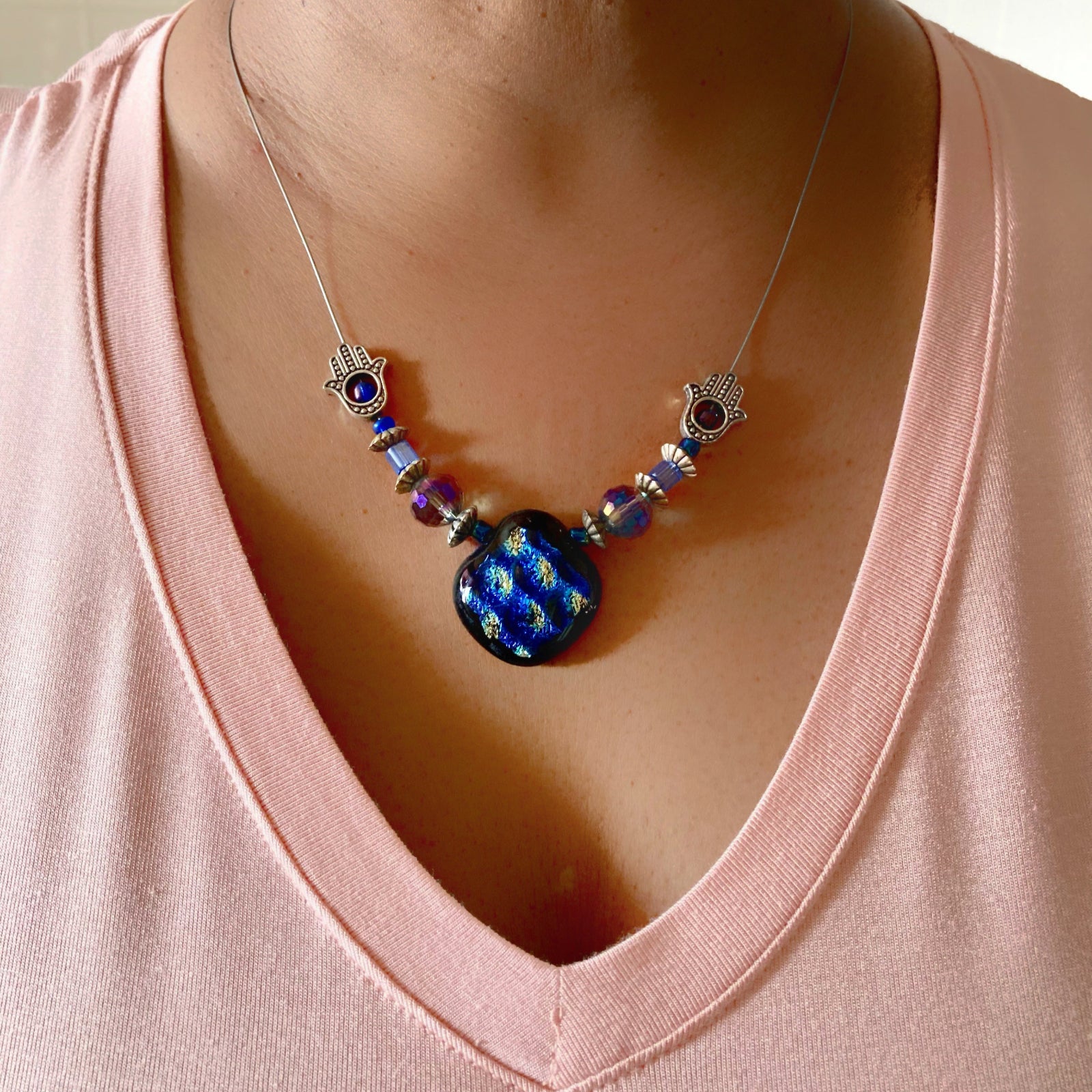 Model wearing beaded pendant necklace and a peach-colored shirt, by 3D Glass Designs.