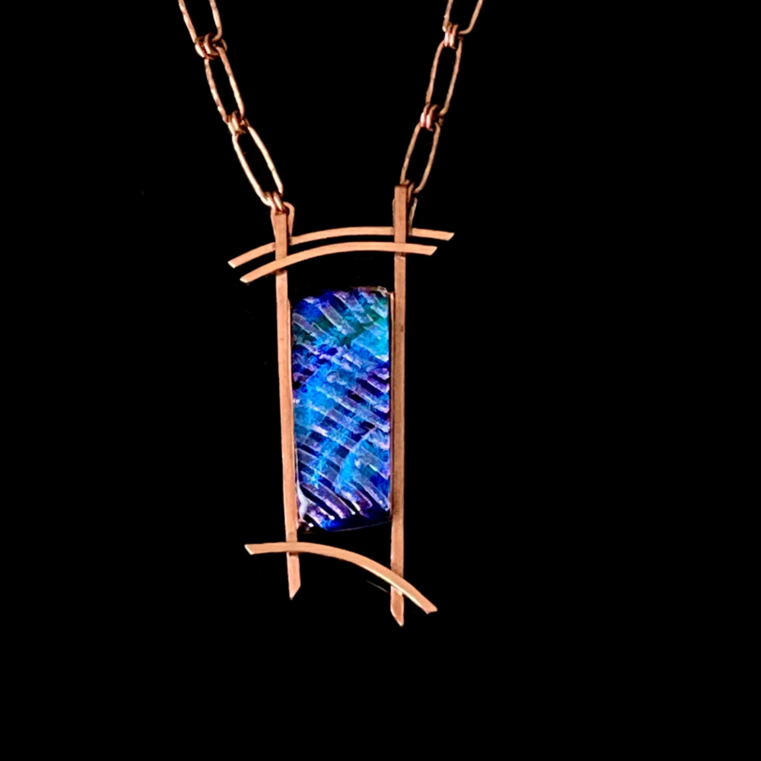 Blue dichroic glass set in a handcrafted copper pendant with an Asian design. Handmade copper paperclip link chain completes the design, by 3D Glass Designs