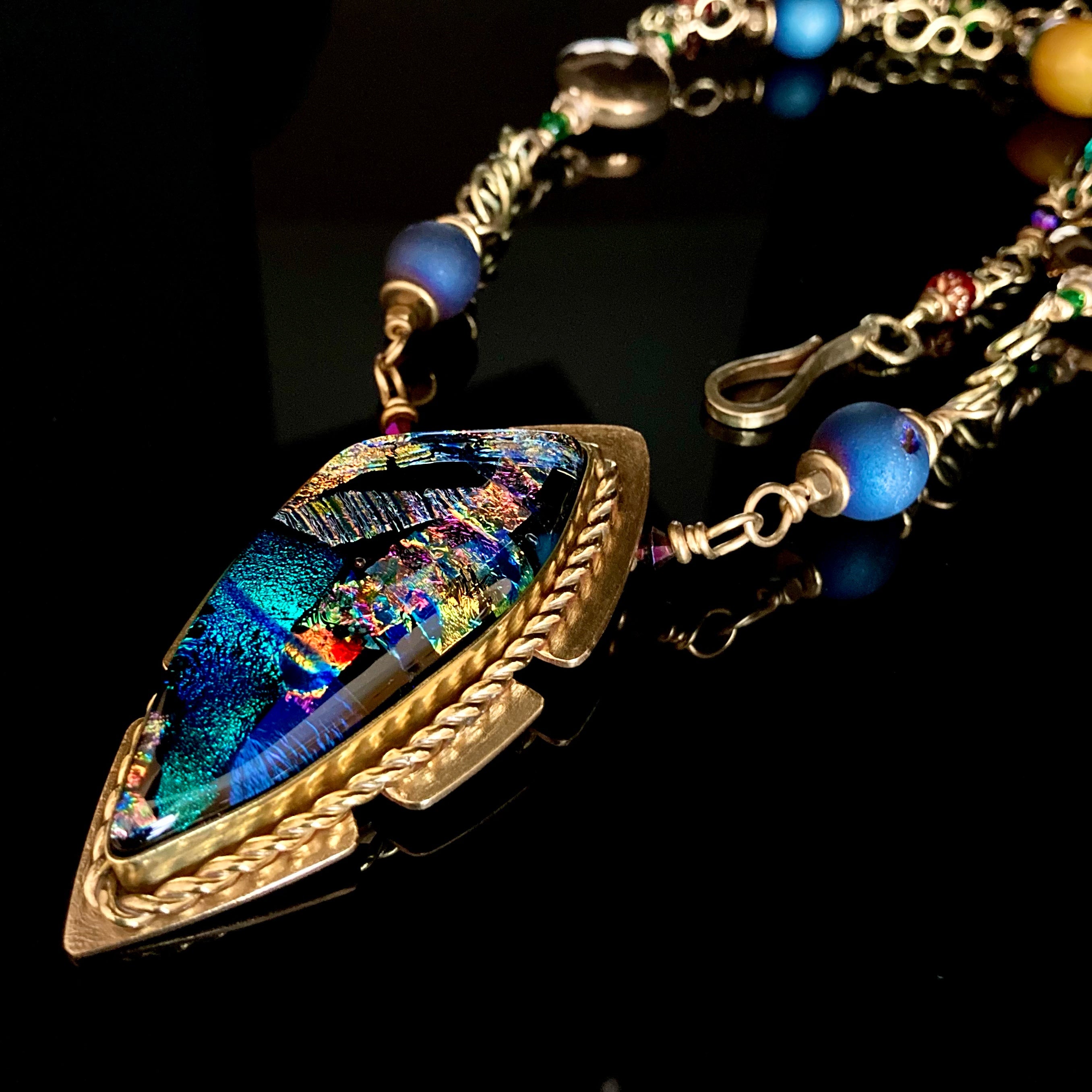 Multicolor handcrafted dichroic glass pendant set in brass, with a handmade beaded chain. By 3D Glass Designs.