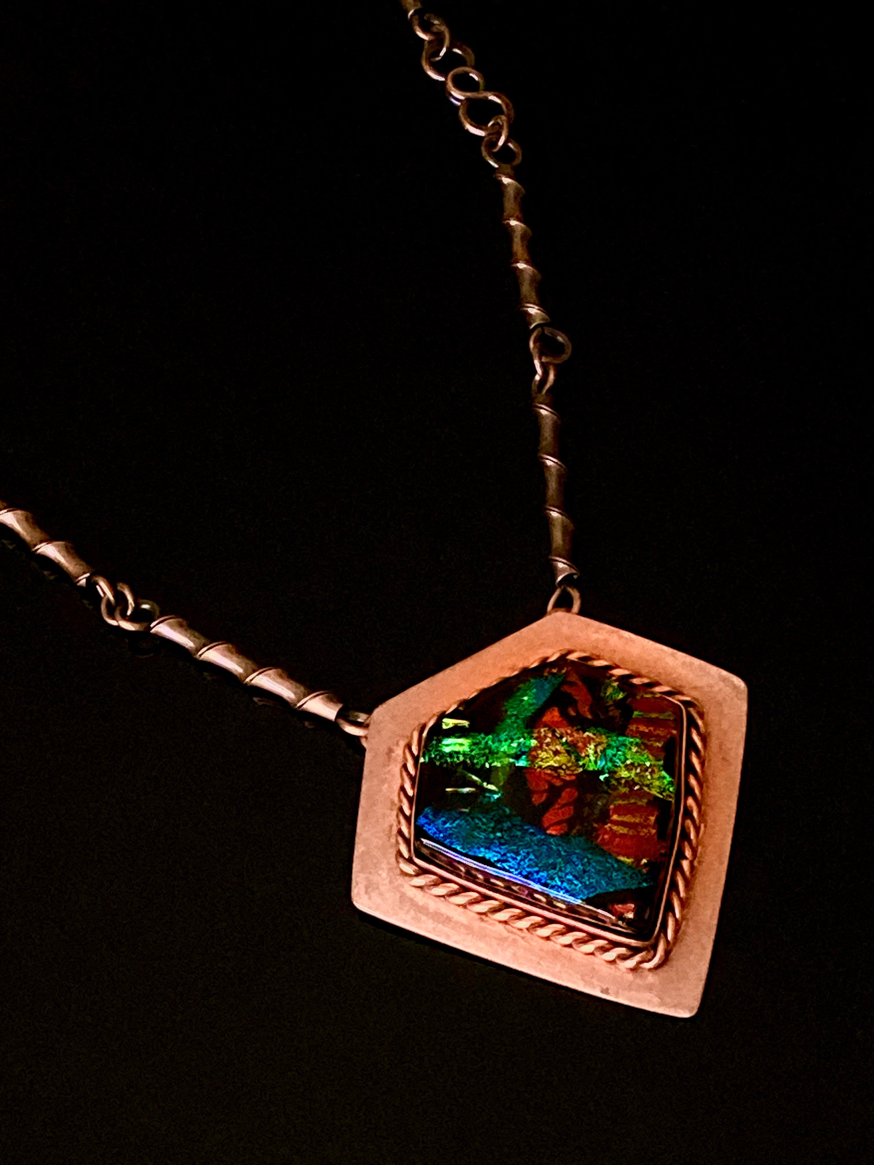 Handcrafted artisan fused glass and copper pendant necklace by 3D Glass Designs.  Dichroic glass in blue, green and rust hues set in a handcrafted diamond-shaped shield copper pendant with an elegant rope detail surrounding the bezel.  The handmade copper necklace consists of twisted copper links that resembles bamboo and a handmade clasp.