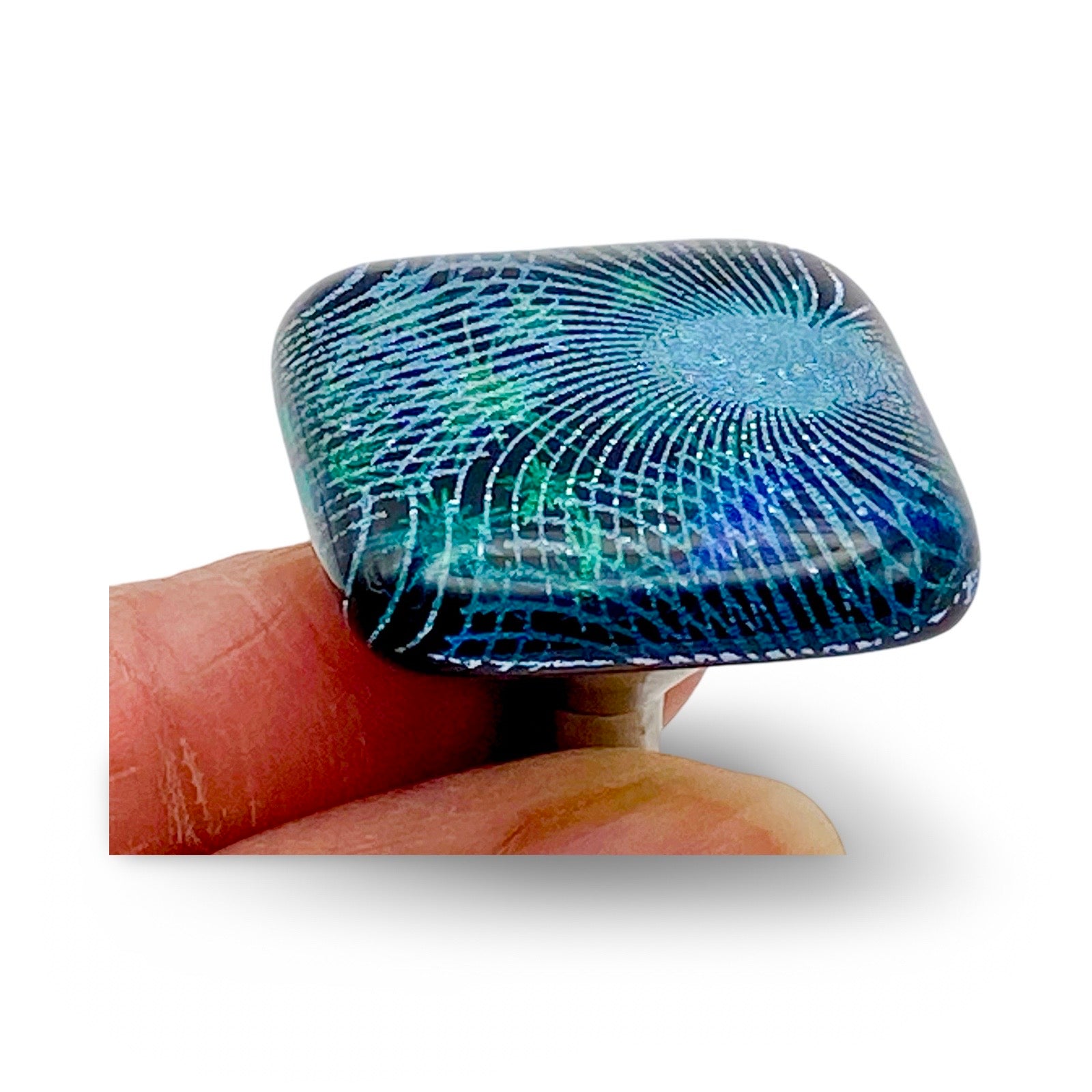 Hand holding handmade fused glass furniture knob, by 3D Glass Designs.