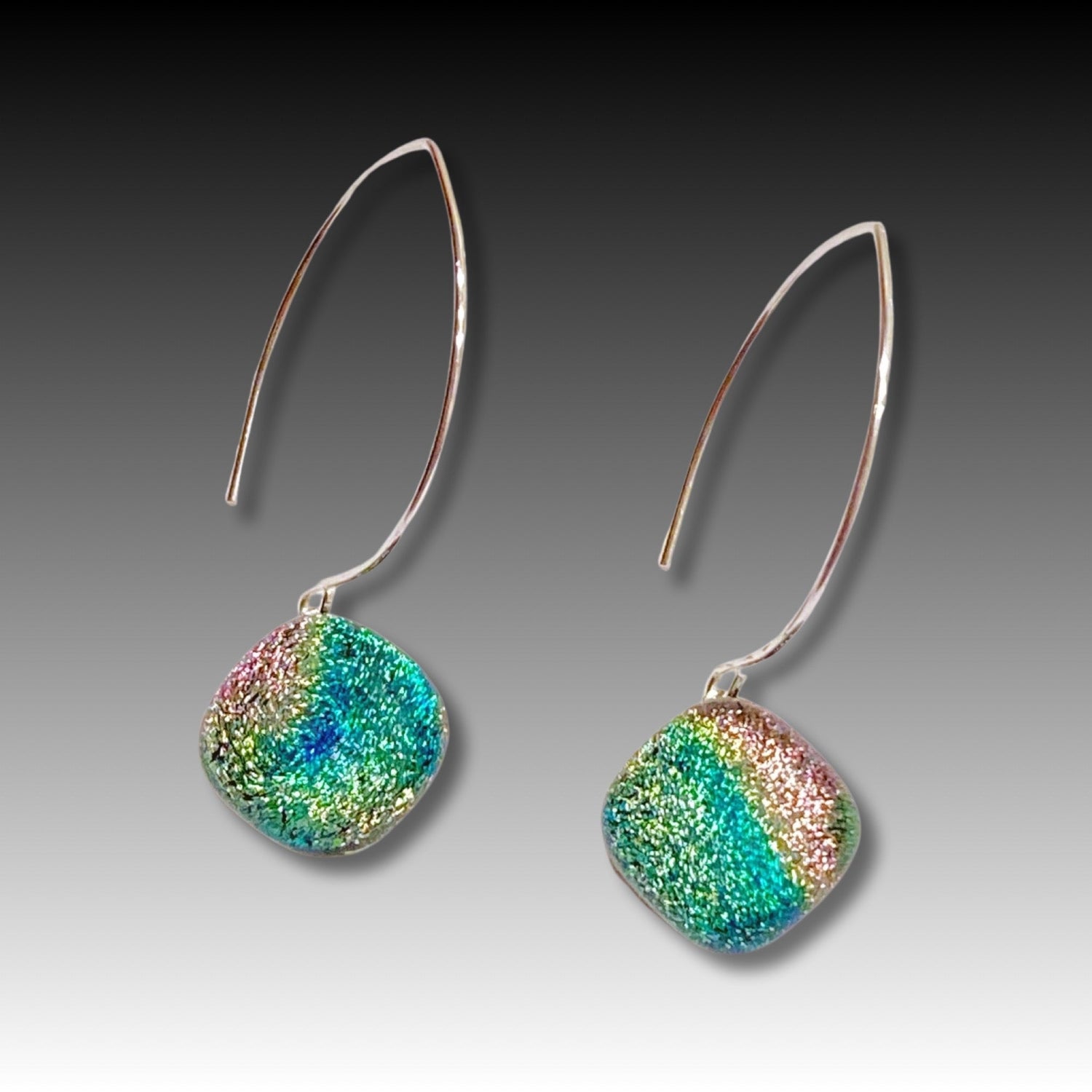 A pair of long earrings with fused glass dangles, by 3D Glass Designs.