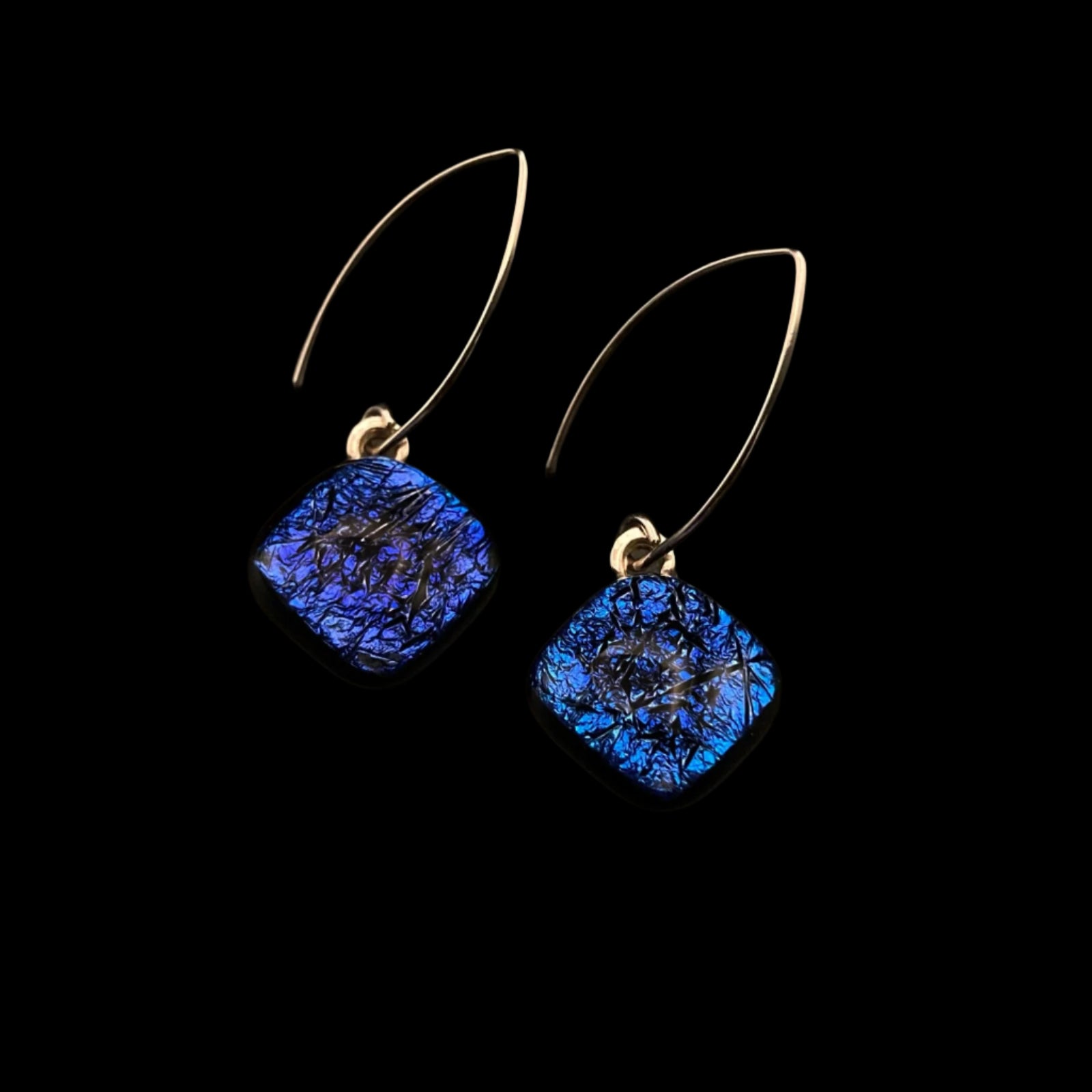A pair of diamond-shaped  glass earrings with silver ear wires against a black background, by 3D Glass Designs.