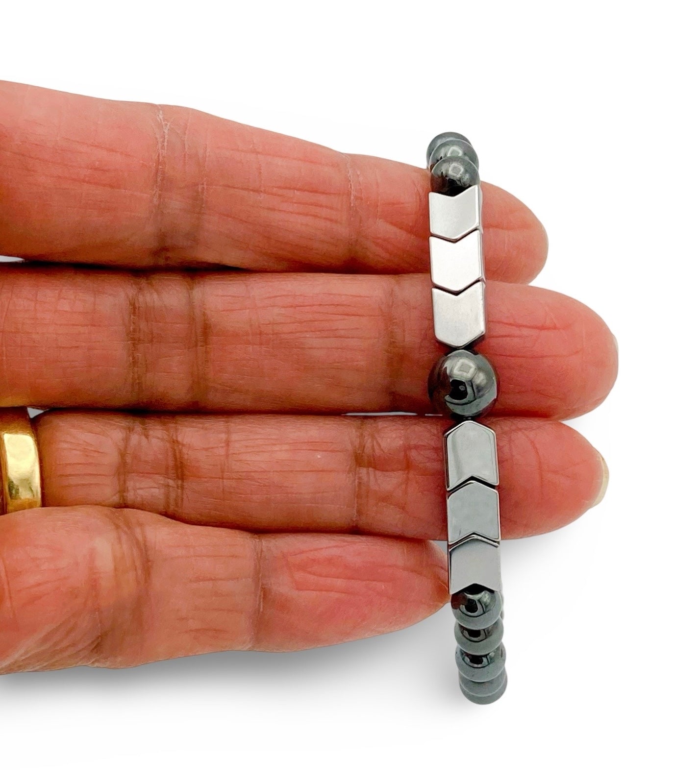 Hand holding men's beaded hematite bracelet, by 3D Glass designs.